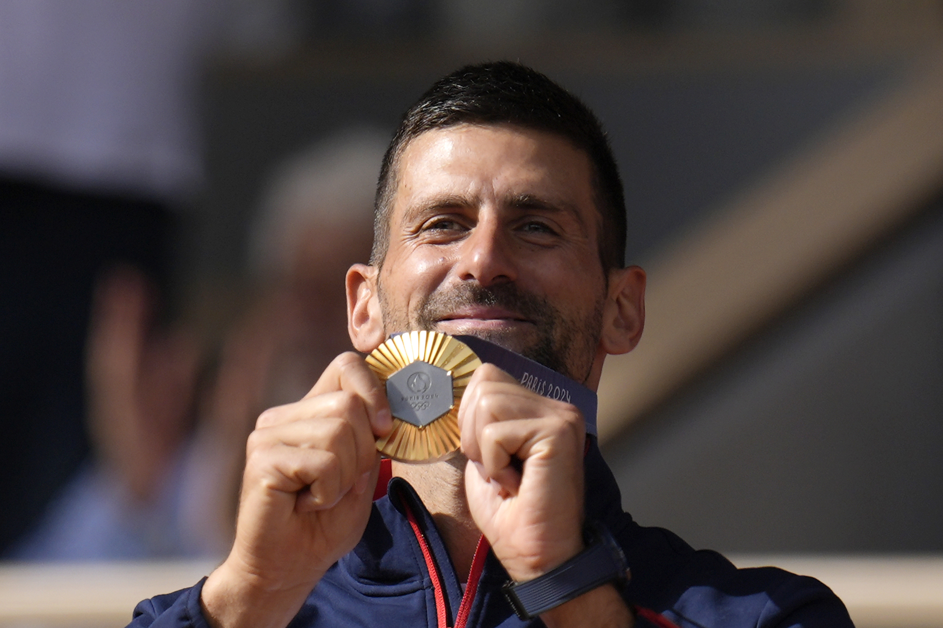 Serbia's Novak Djokovic shows his gold medal after defeating Spain's Carlos Alcaraz.