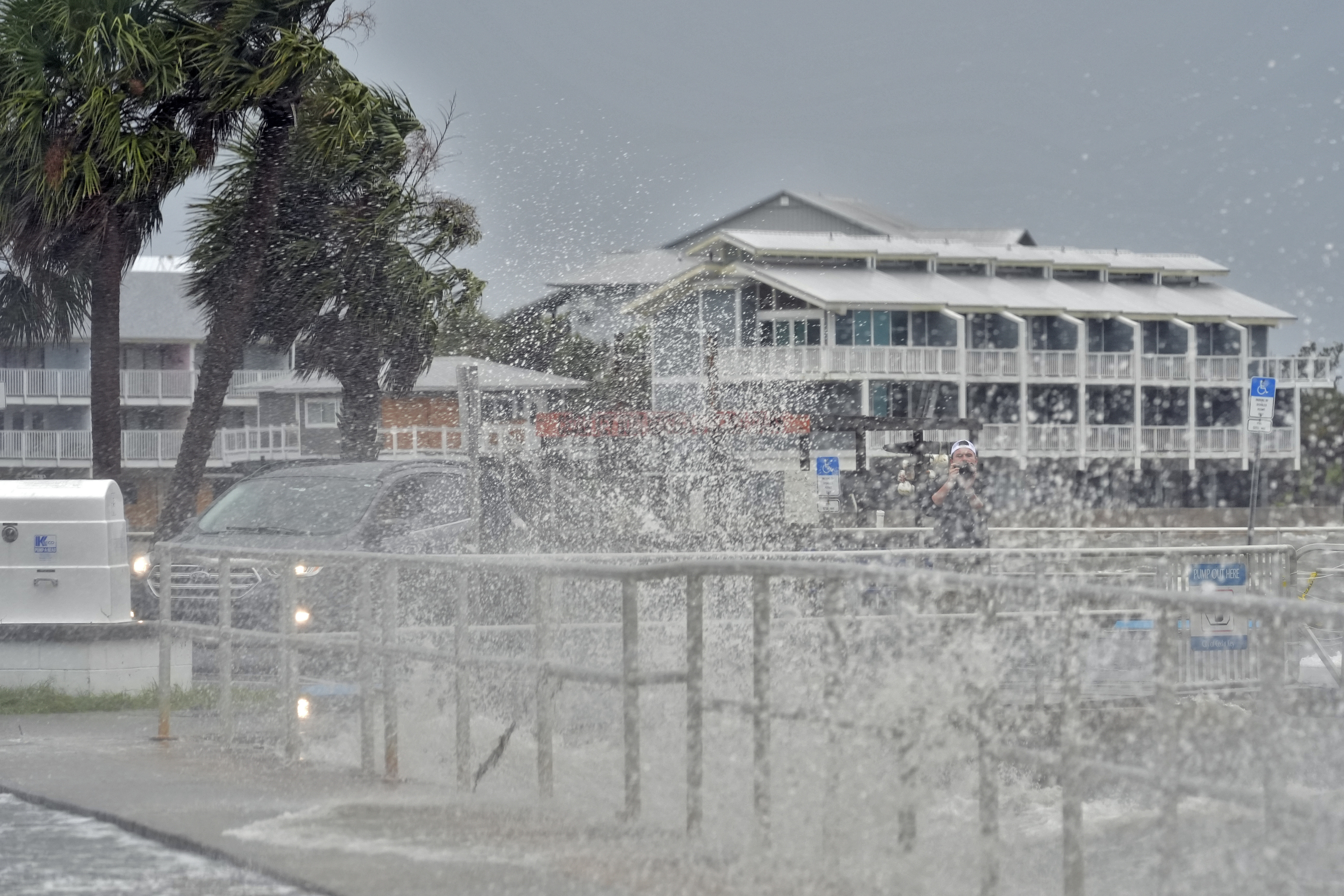 A man takes photos of the surf, pushed by winds from Tropical Storm Debby.