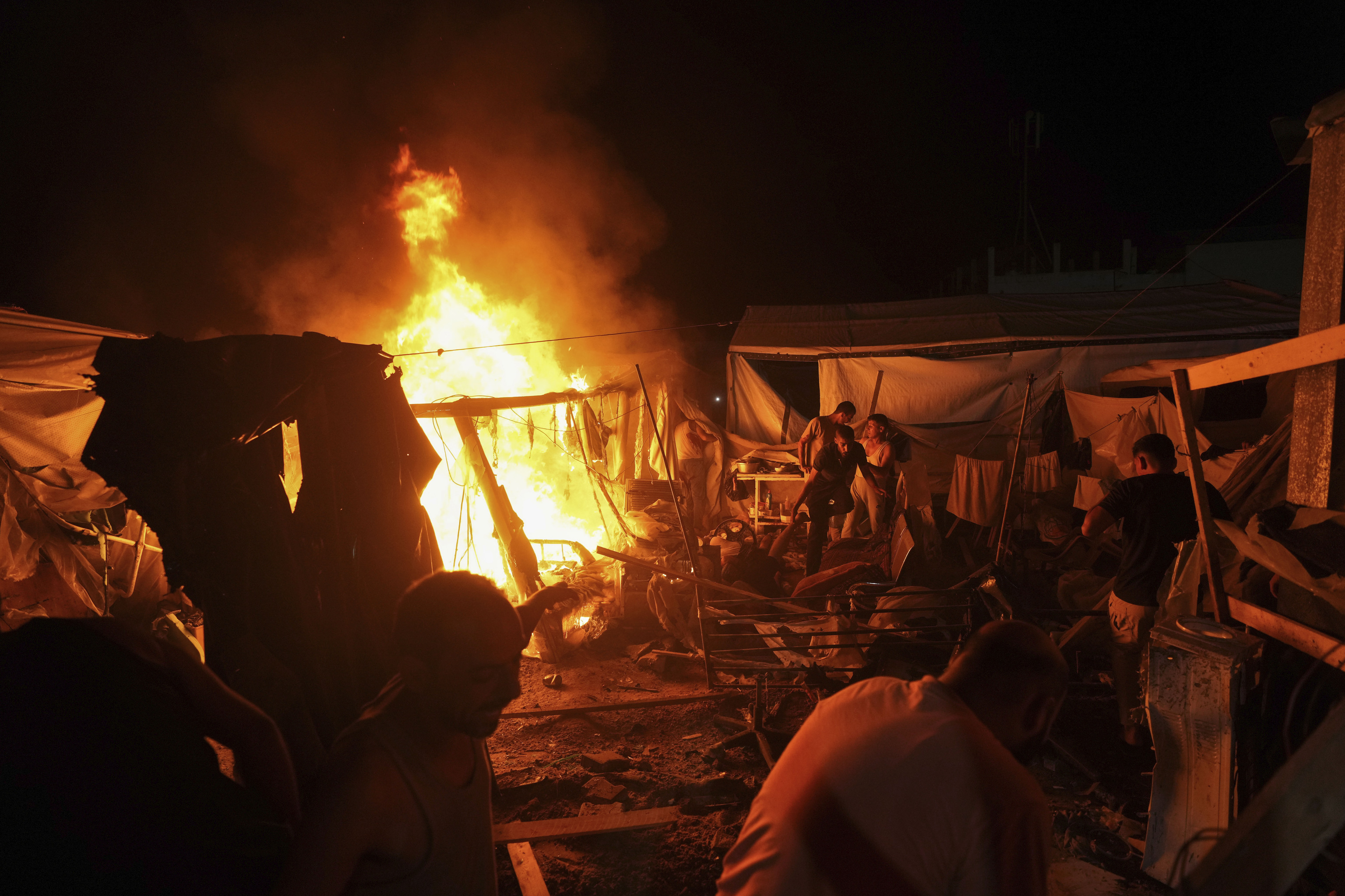 Palestinians react to fire from an Israeli strike that hit a tent area.