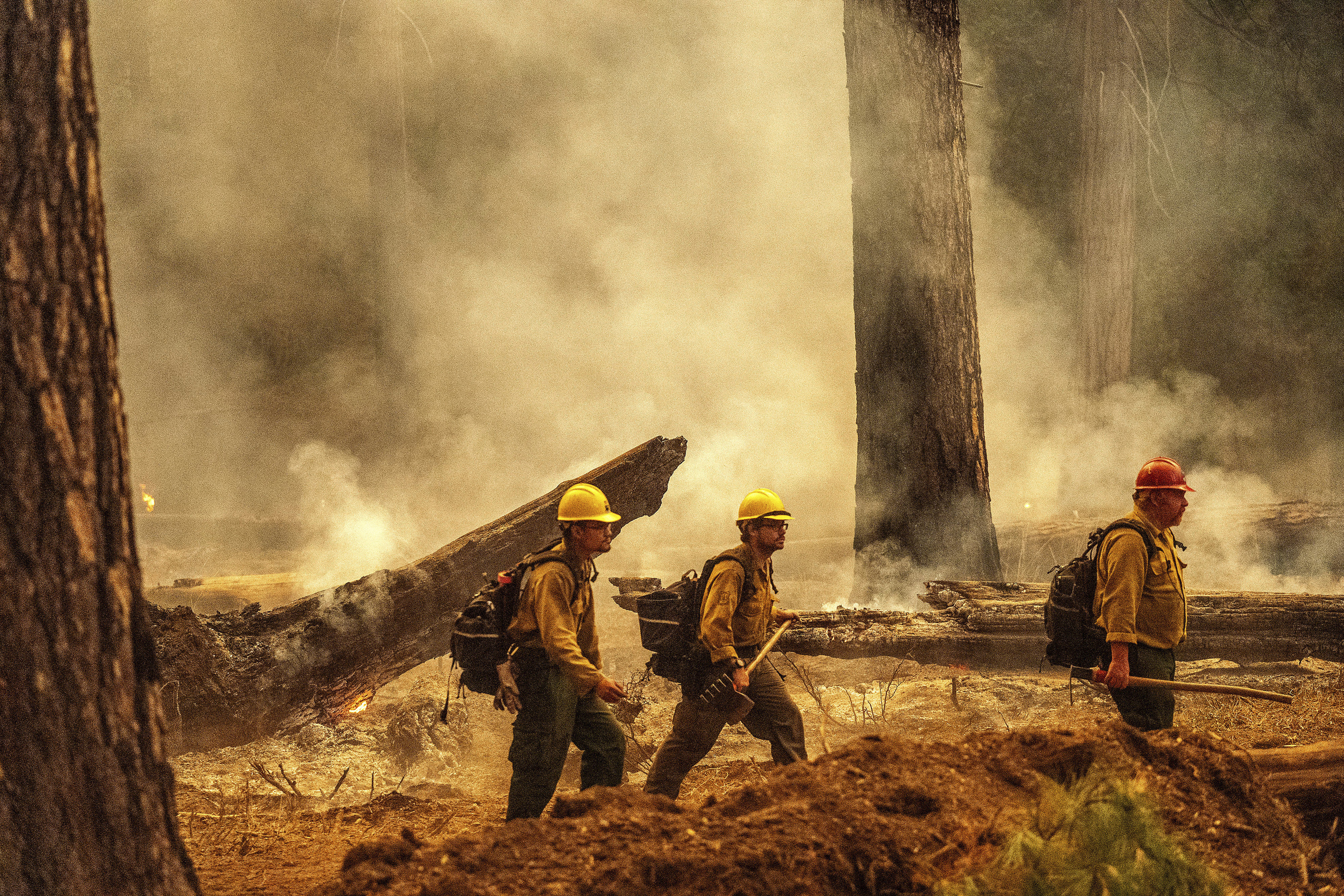 Firefighters pass smoke from a backfire.