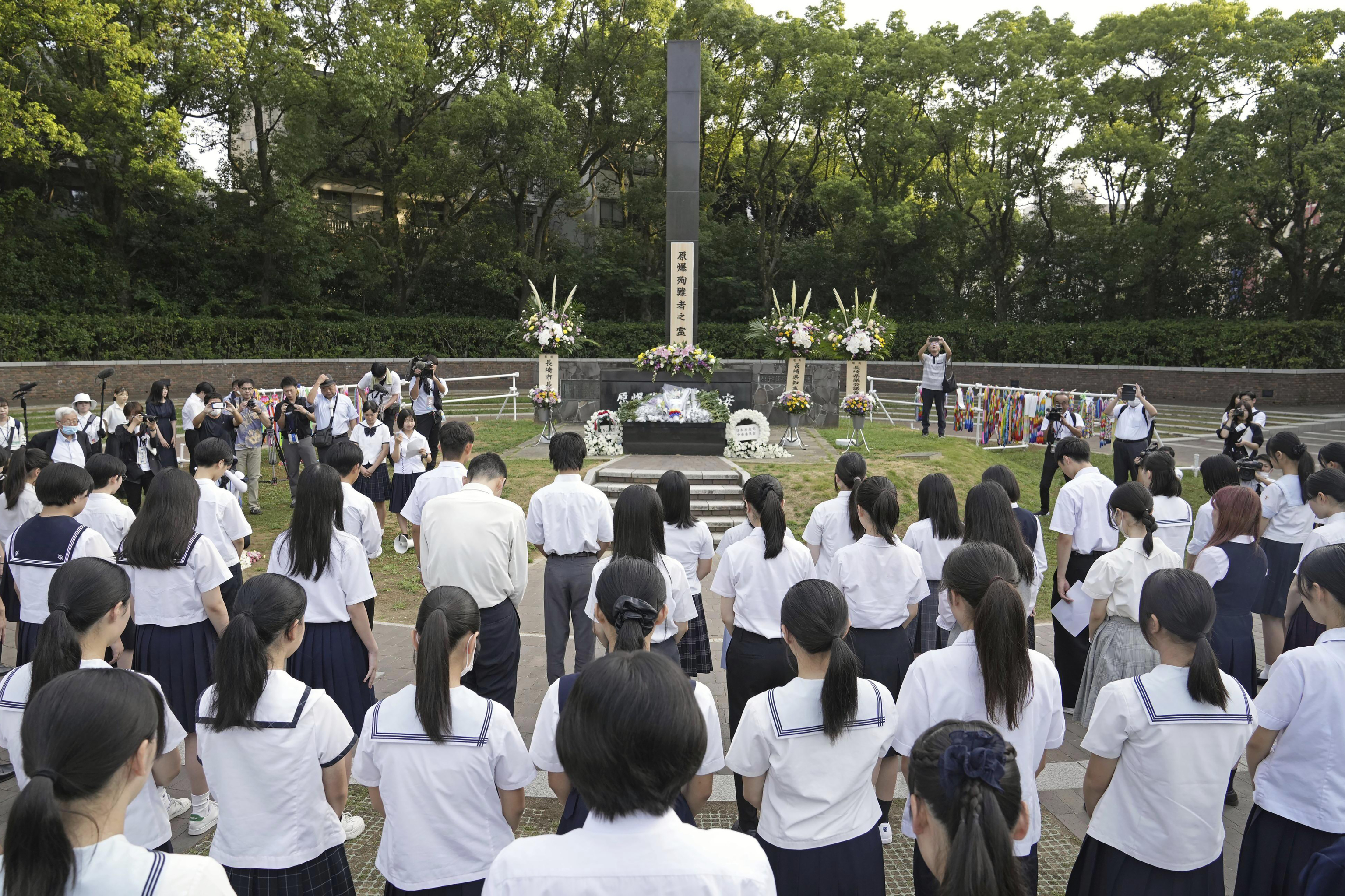 High school students and others offer silent prayers in front of the memorial of the atomic boming hypercenter in Nagasaki.