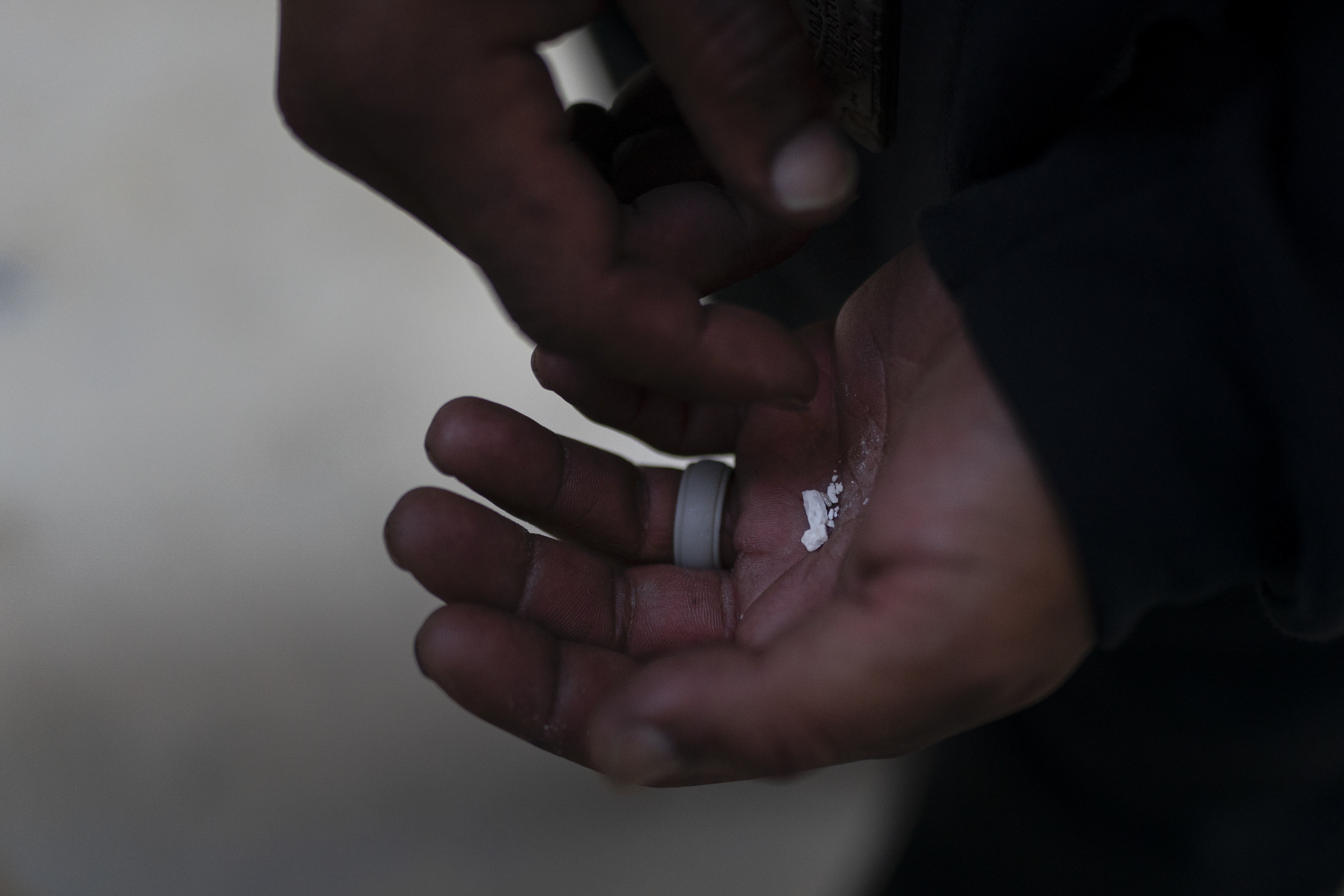 A homeless addict holds pieces of fentanyl in Los Angeles