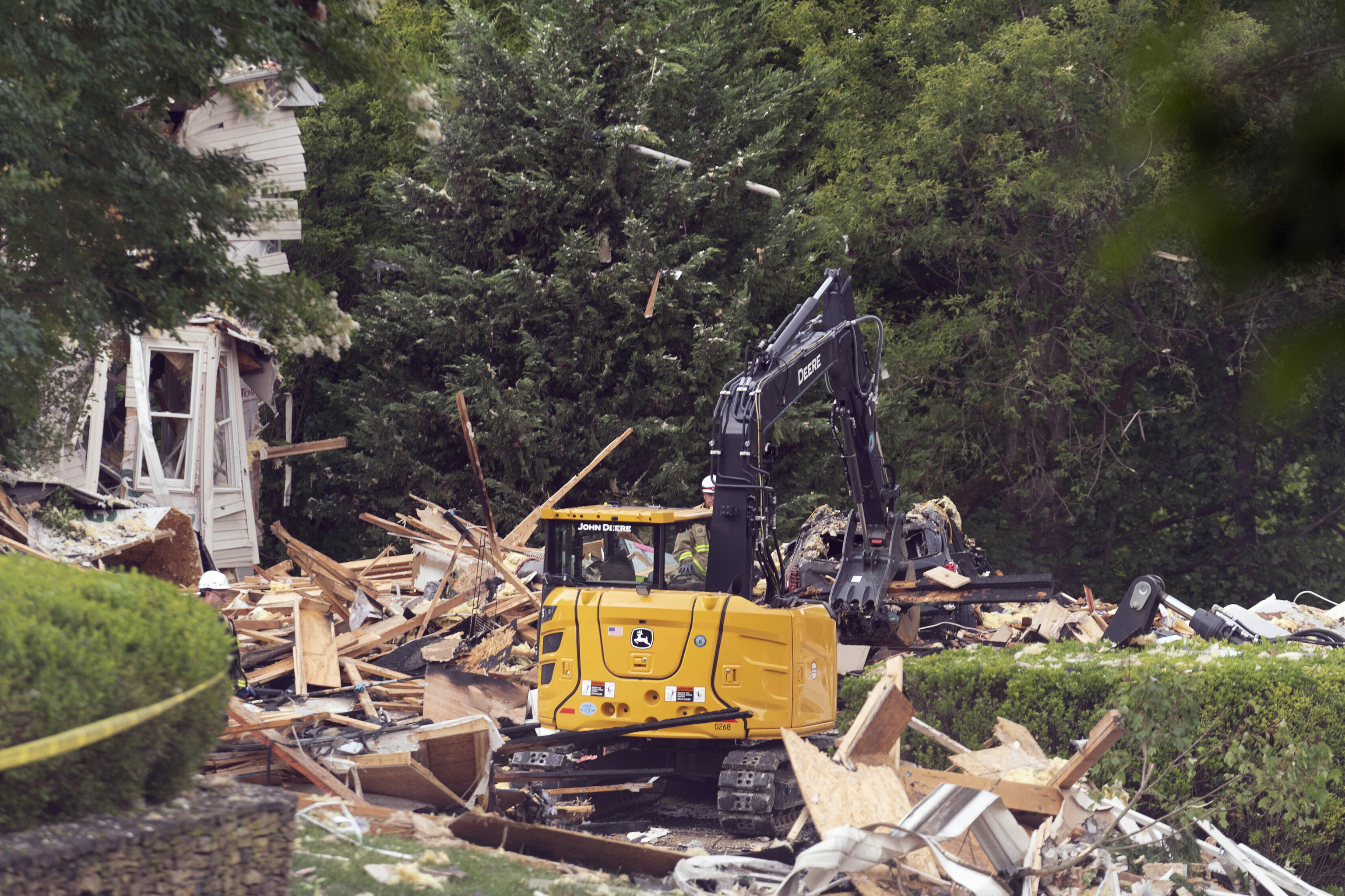 Crew workers remove debris after a house exploded in the Bel Air, Md. neighborhood on Sunday,