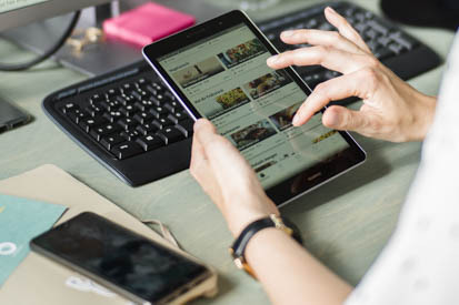 A woman uses a tablet, a computer and a mobile