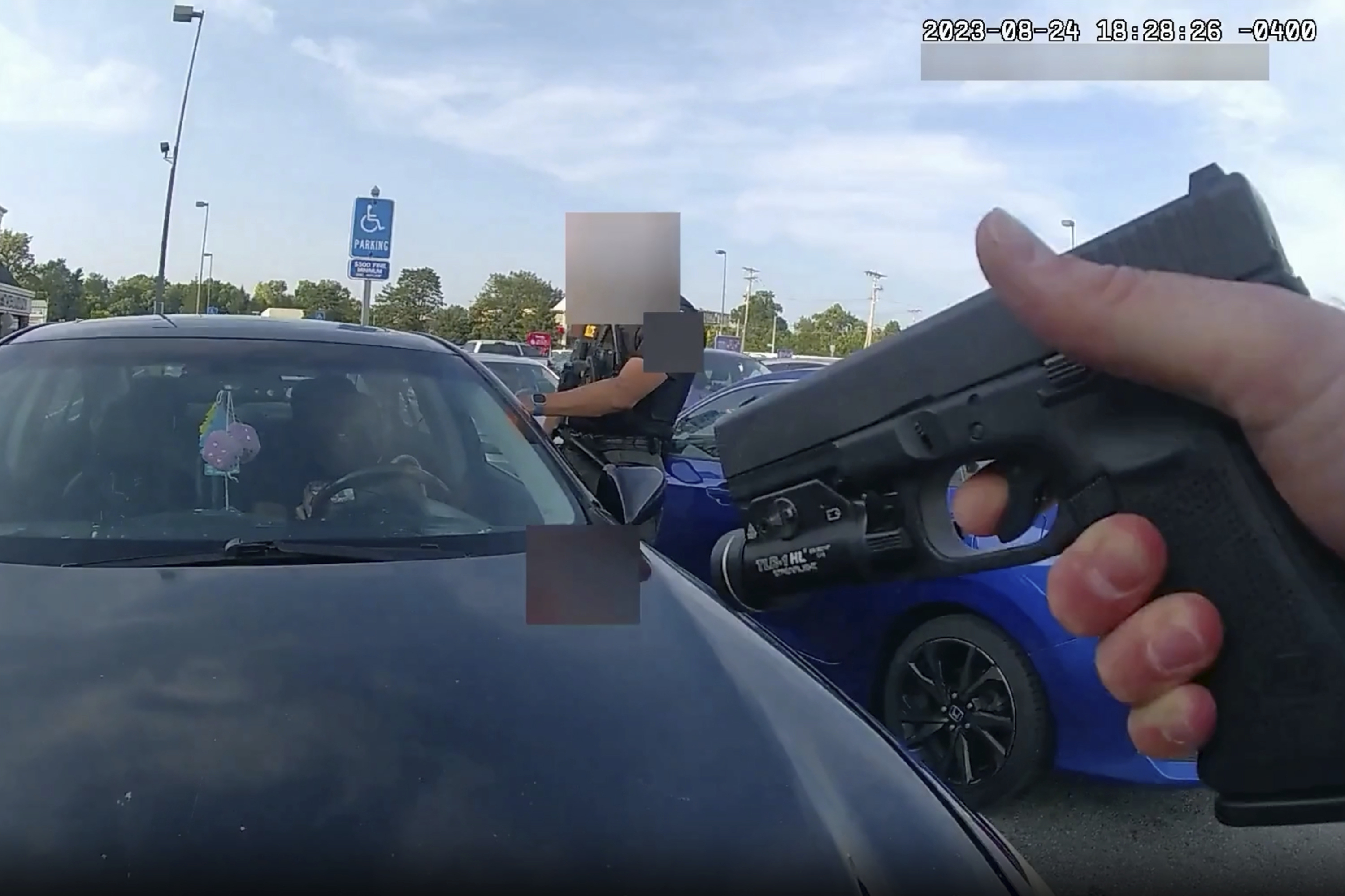 An officer pointing his gun at Ta'Kiya Young moments before shooting