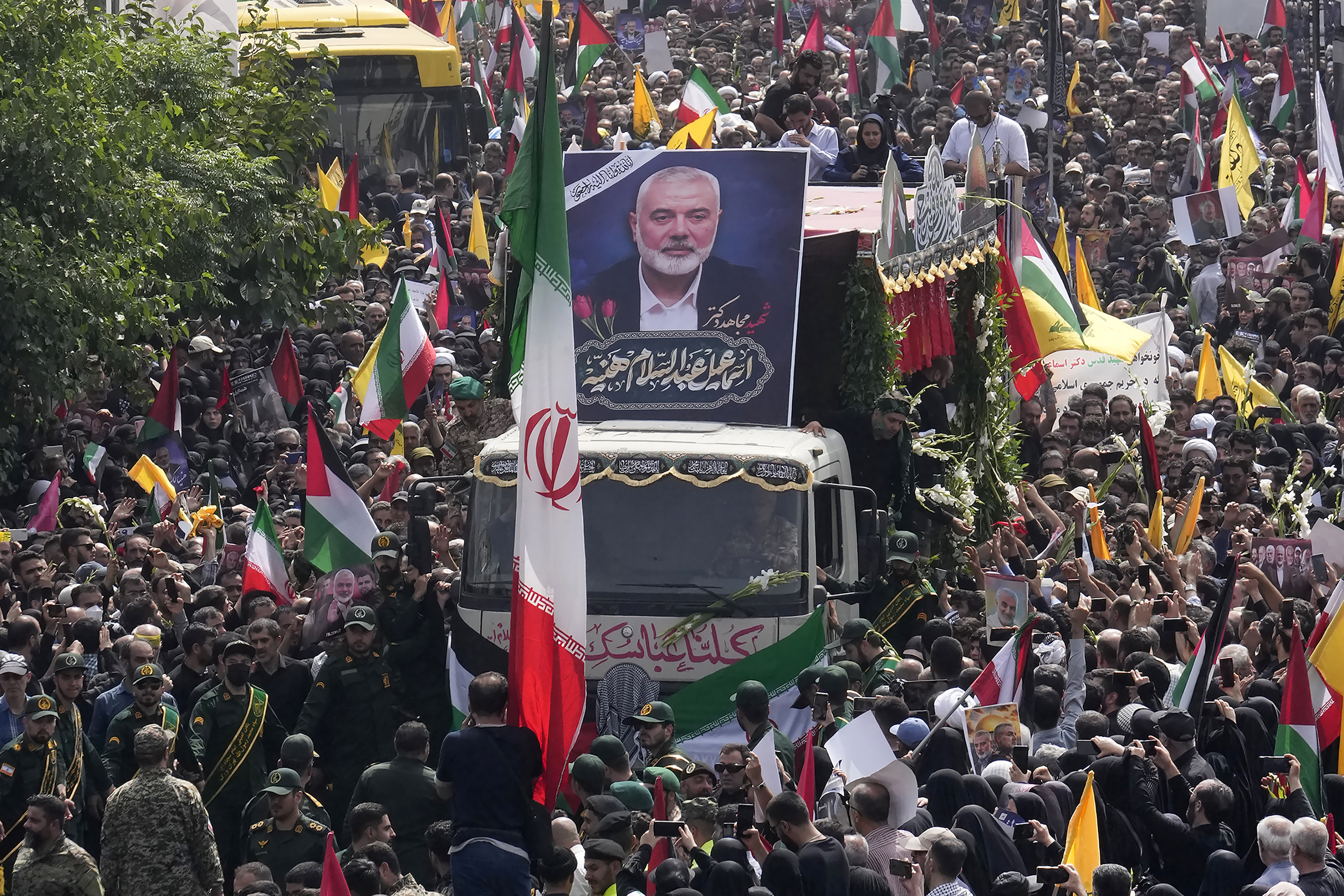 ranians follow a truck, center, carrying the coffins of Hamas leader Ismail Haniyeh