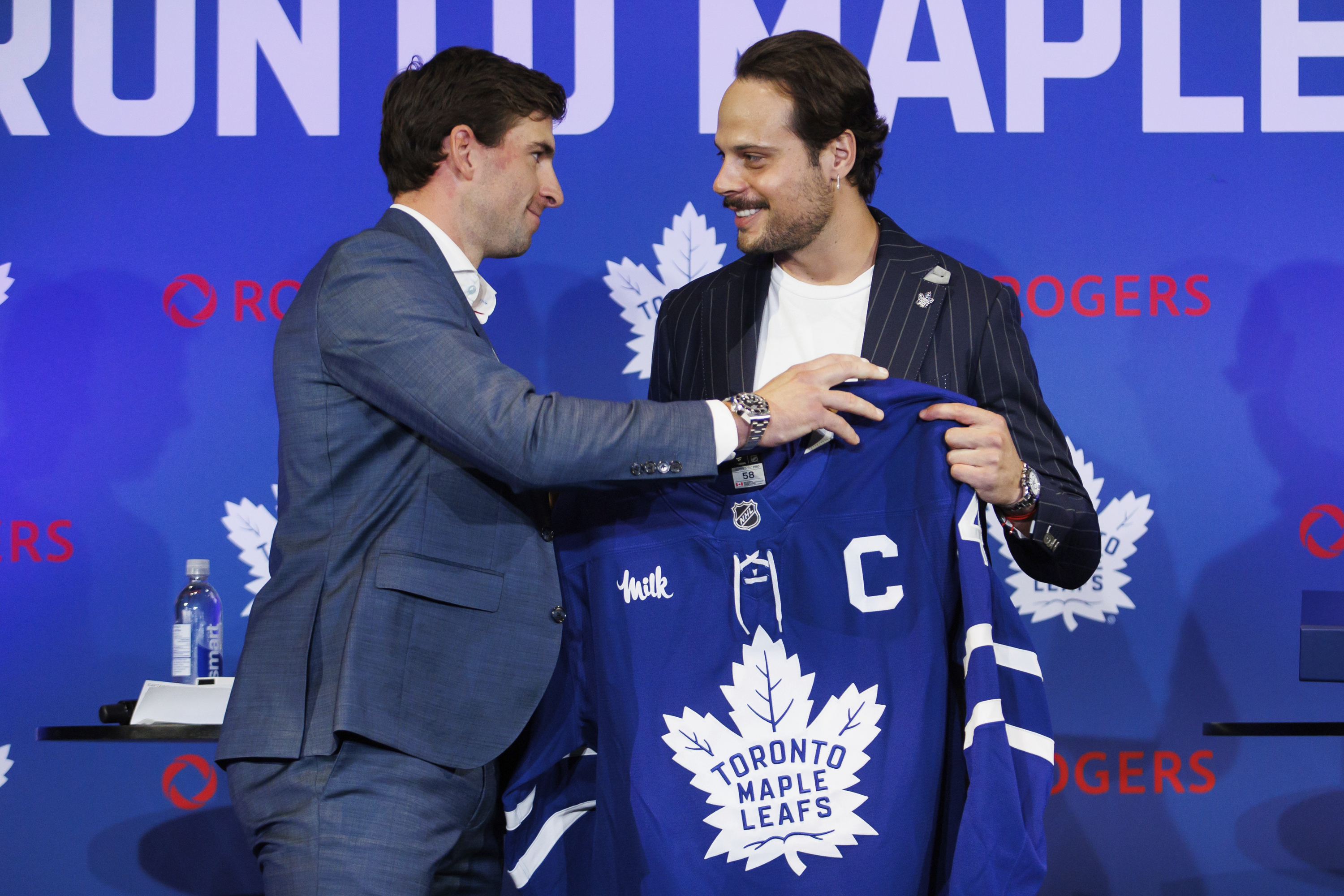 Former Toronto Maple Leafs captain John Tavares, left, hands the captains jersey to Maple Leafs new captain Auston Matthews