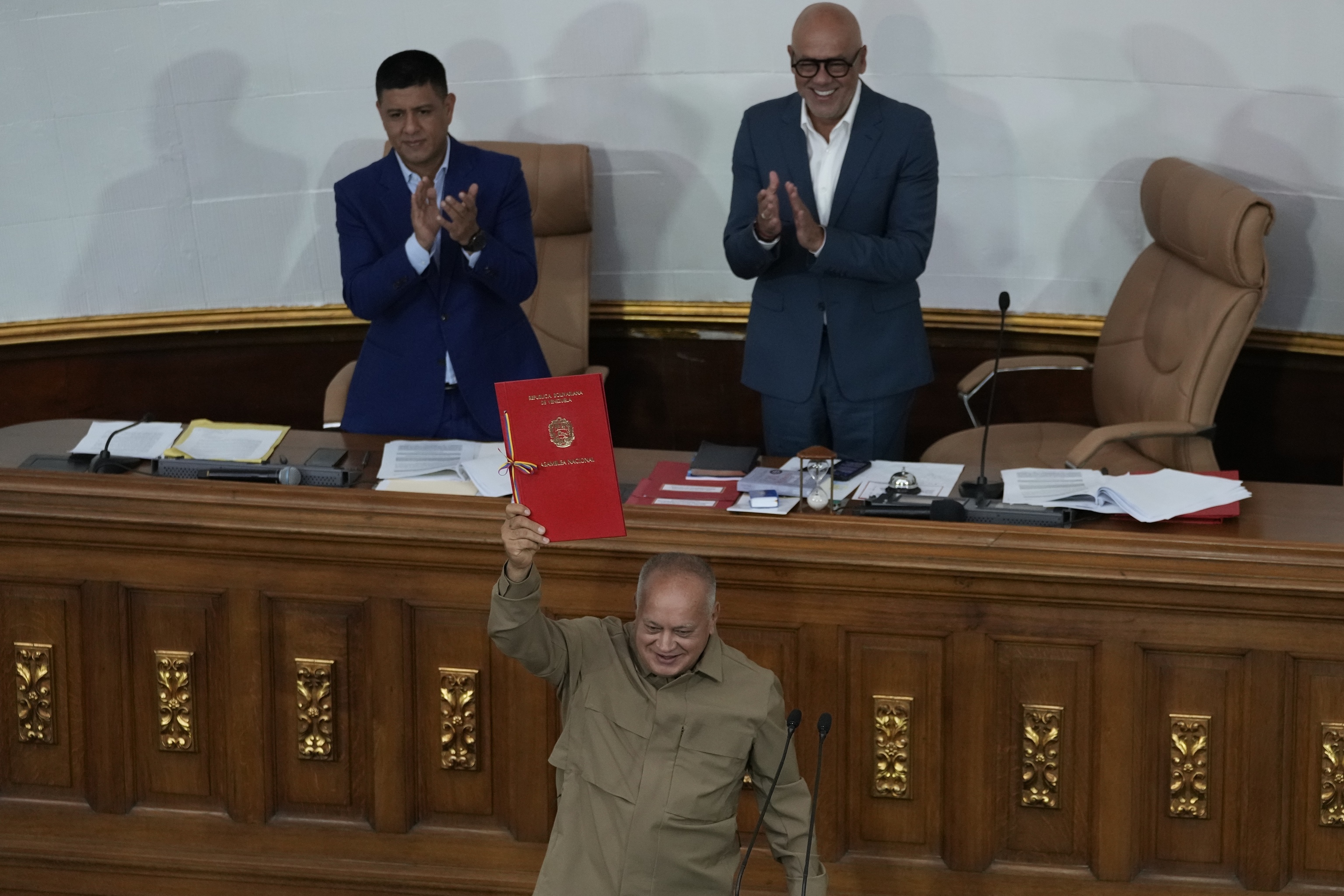 National Assembly President Jorge Rodriguez raises his hand approving a bill to regulate NGOs and non-profits, in Congress in Caracas