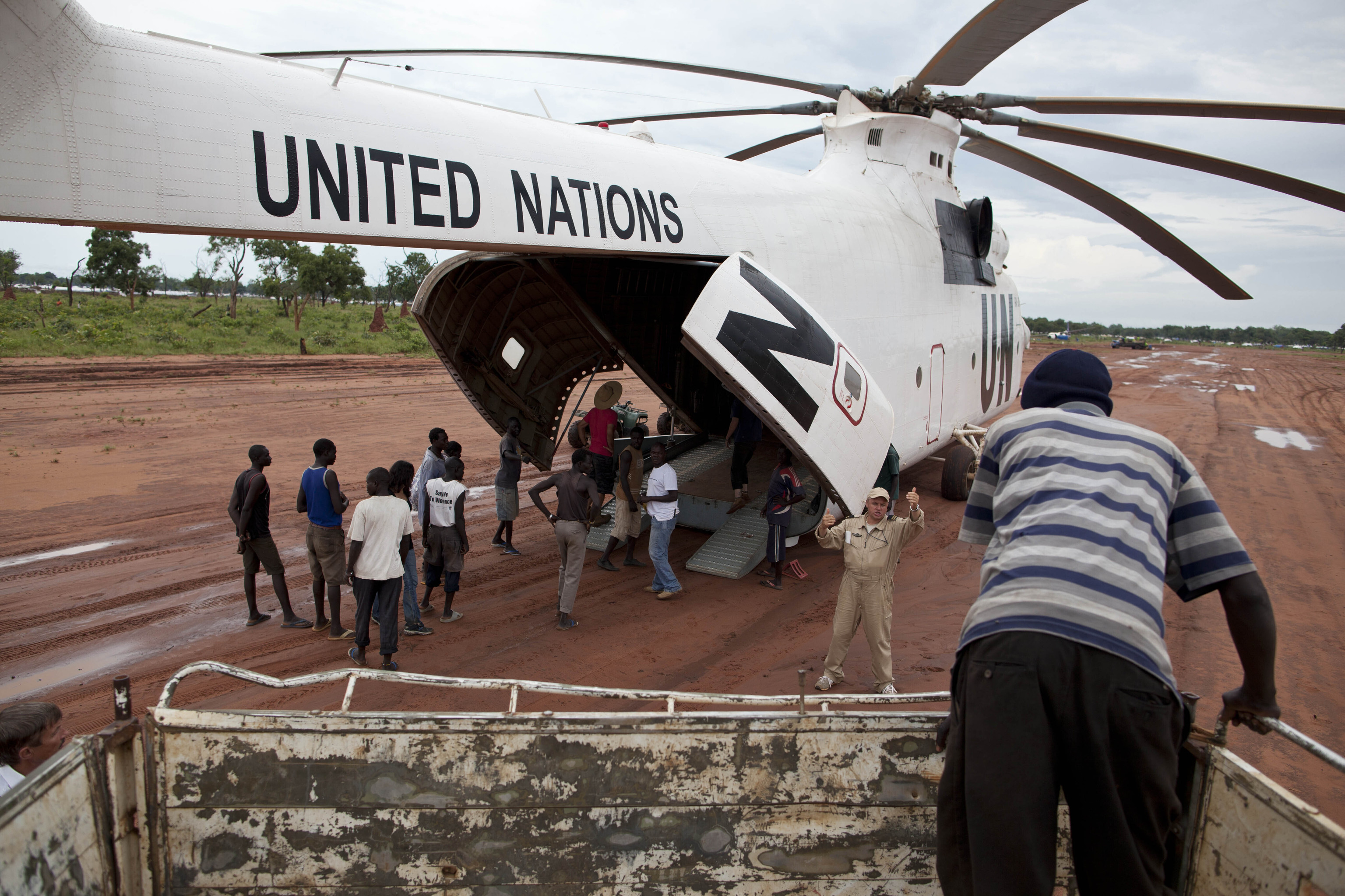 A World Food Programme (WFP) truck backs up to load food items from a recently landed UN helicopter