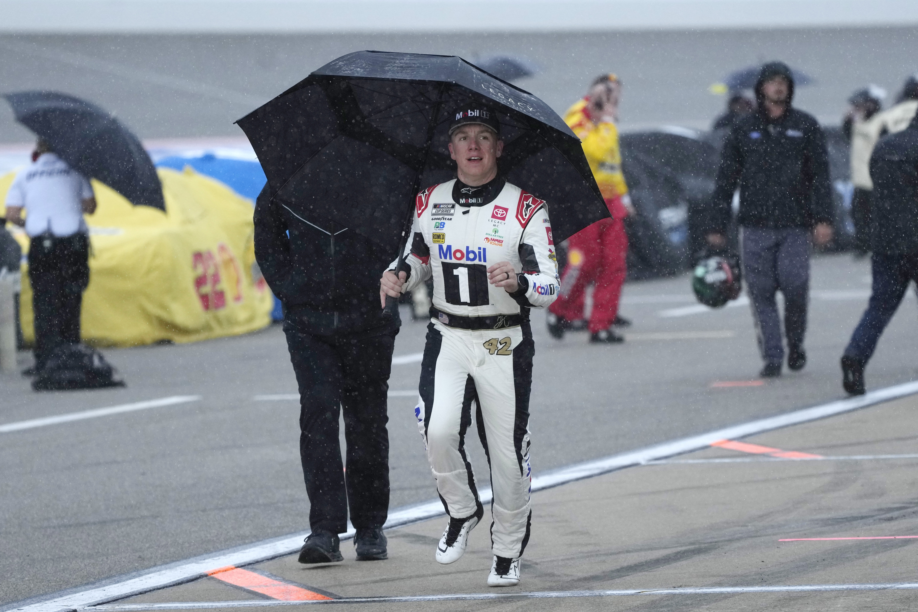 ohn Hunter Nemechek runs to the team trailer after rain stops a NASCAR Cup Series auto race at Michigan International Speedway