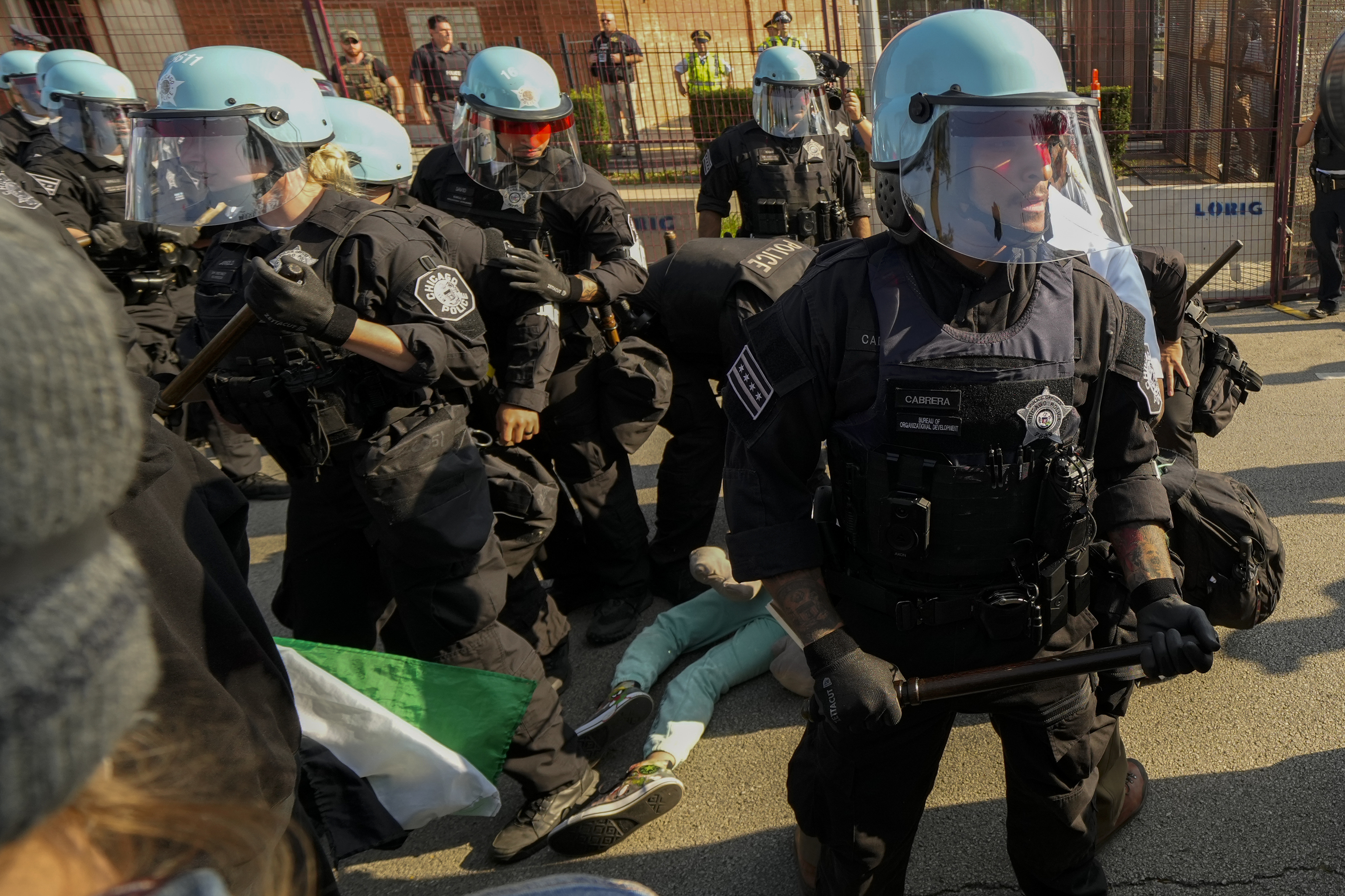 Police take a protester into custody after a fence surrounding United Center was knock down at the Democratic National Convention