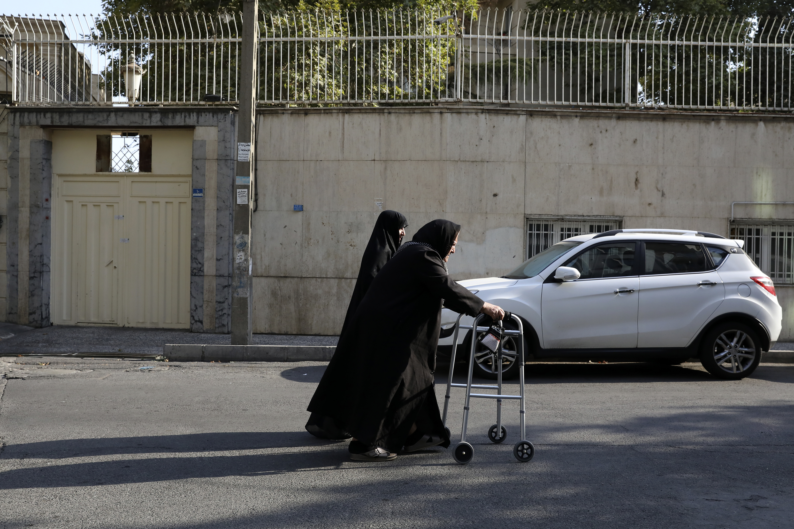 Women walk past the building of a language institute certified by the German embassy, in northern Tehran