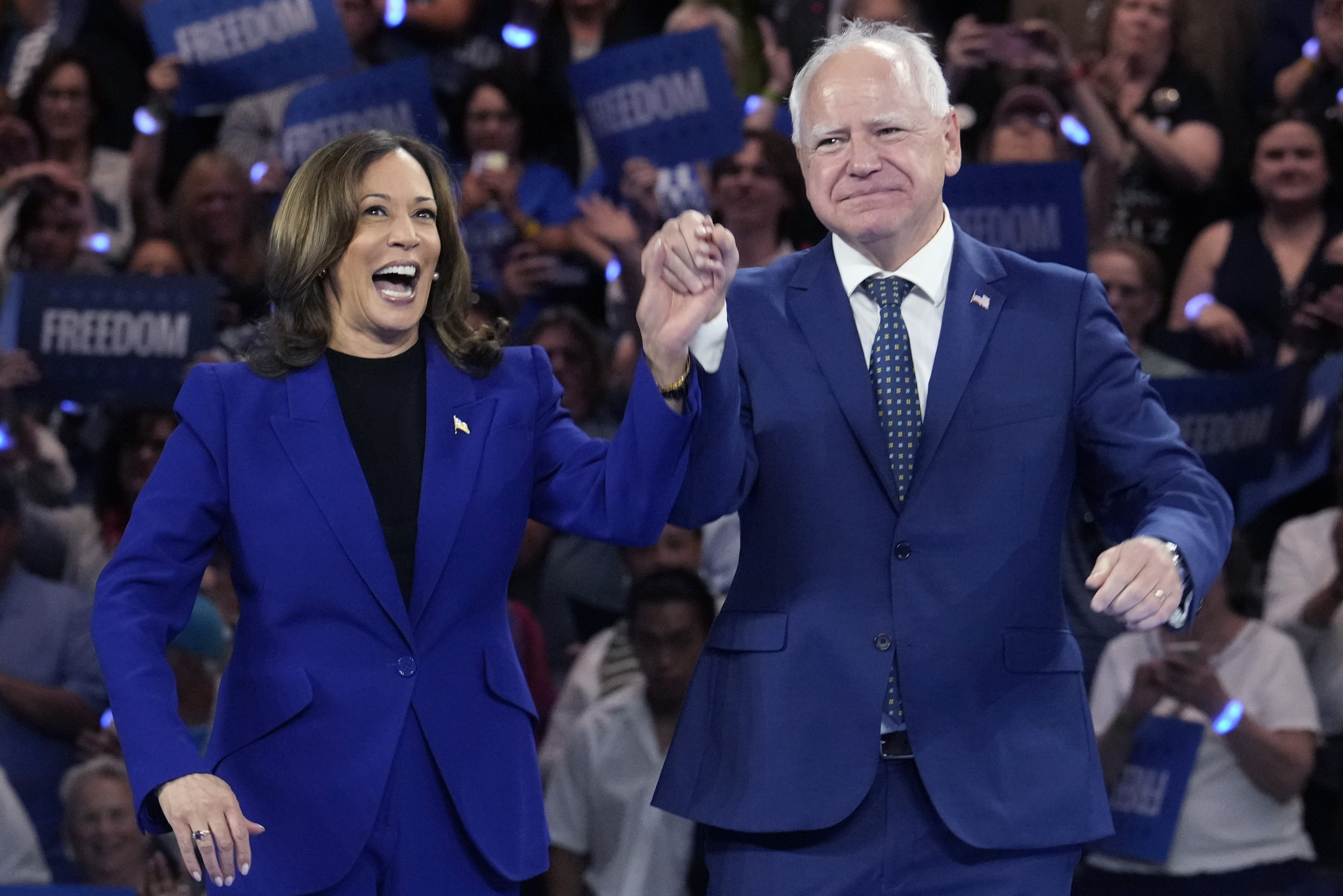 im Walz appear at the Fiserv Forum during a campaign rally