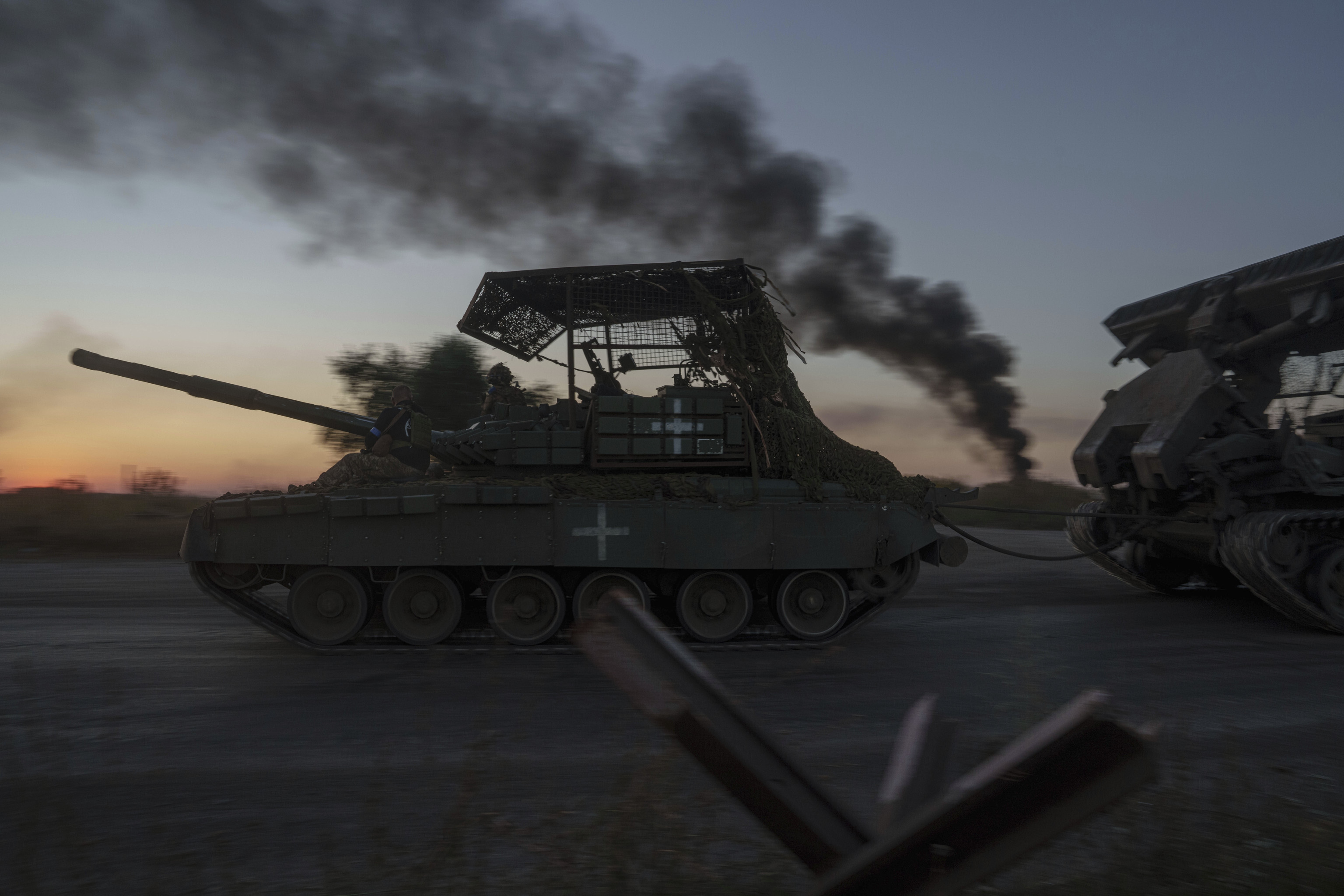 Ukrainian servicemen ride atop a tank after returning from Russia near the Russian-Ukrainian border in Sumy region