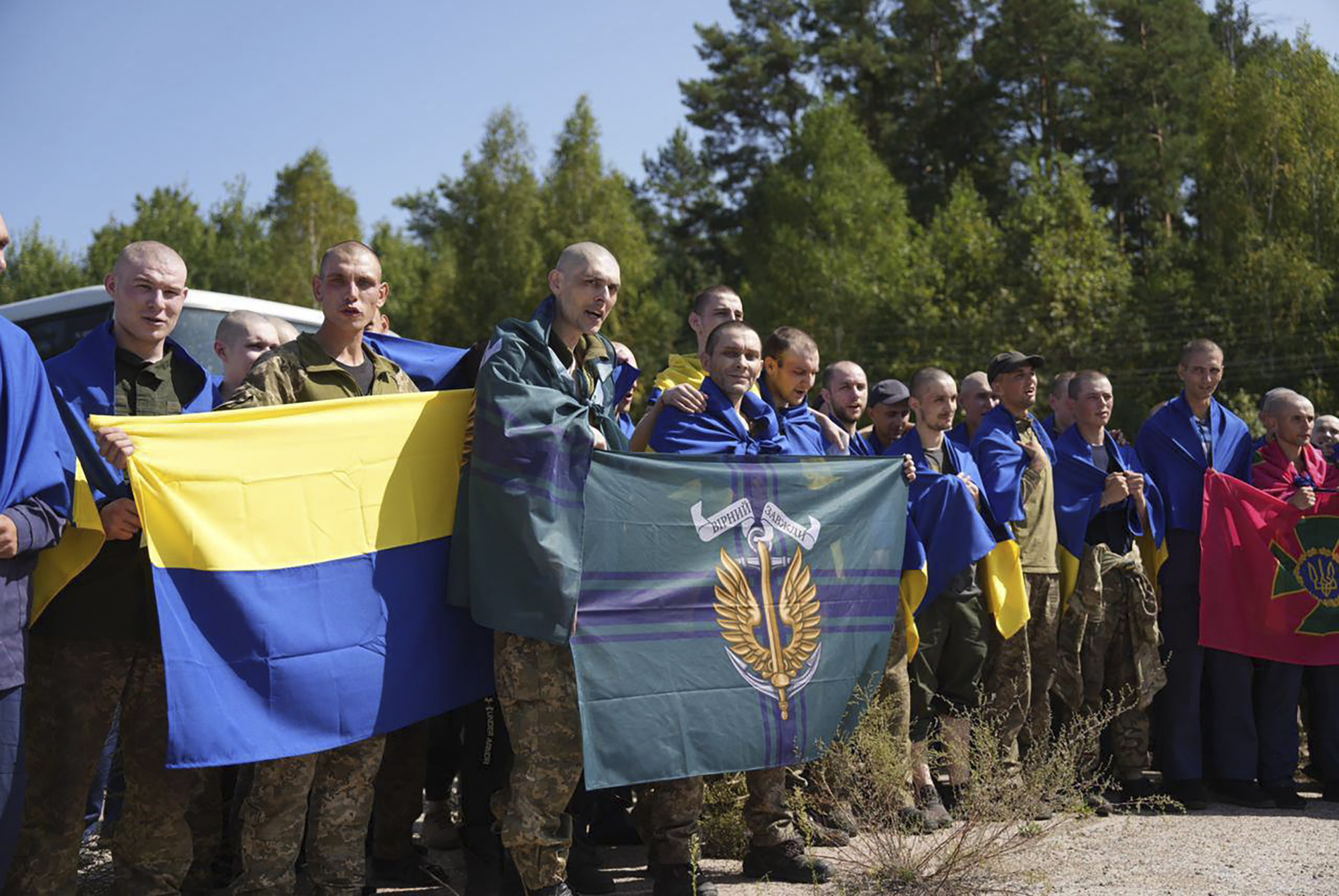 Ukrainian prisoners of war hold their units flags after a prisoners exchange