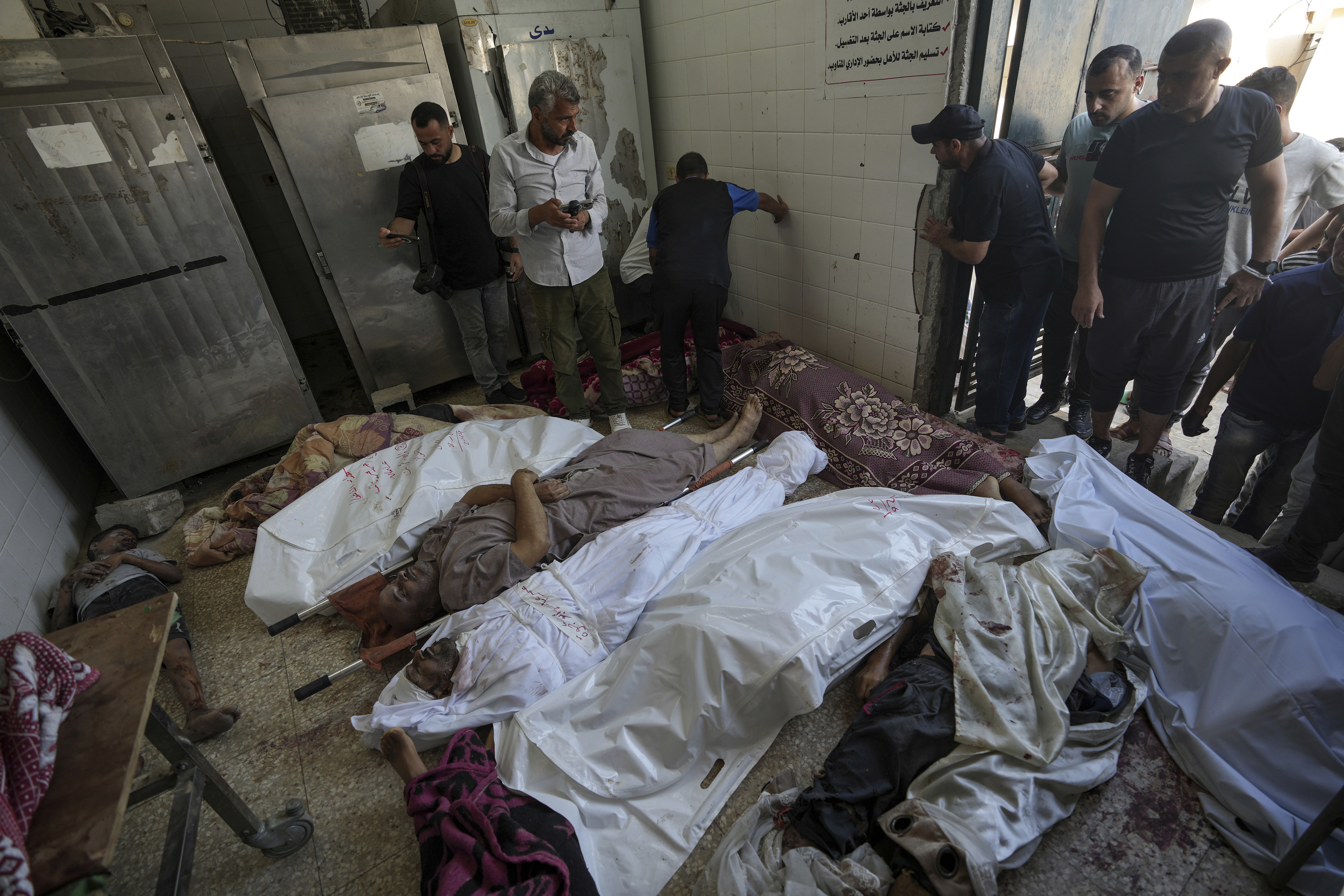 Palestinians check the bodies of their relatives killed in the Israeli bombardment of the Gaza Strip