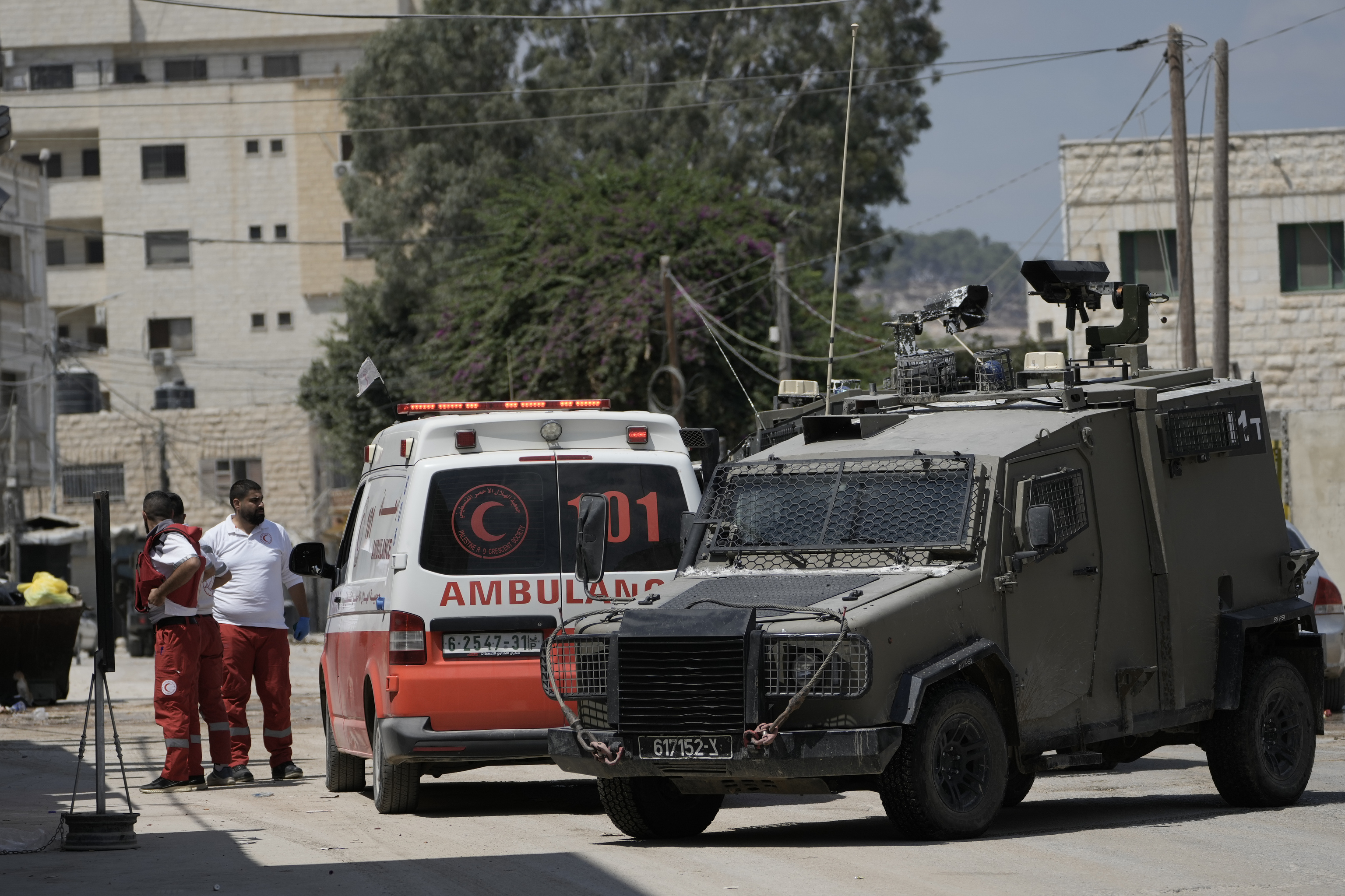 Members of the Israeli forces inside an armoured vehicle check an ambulance during a military operation