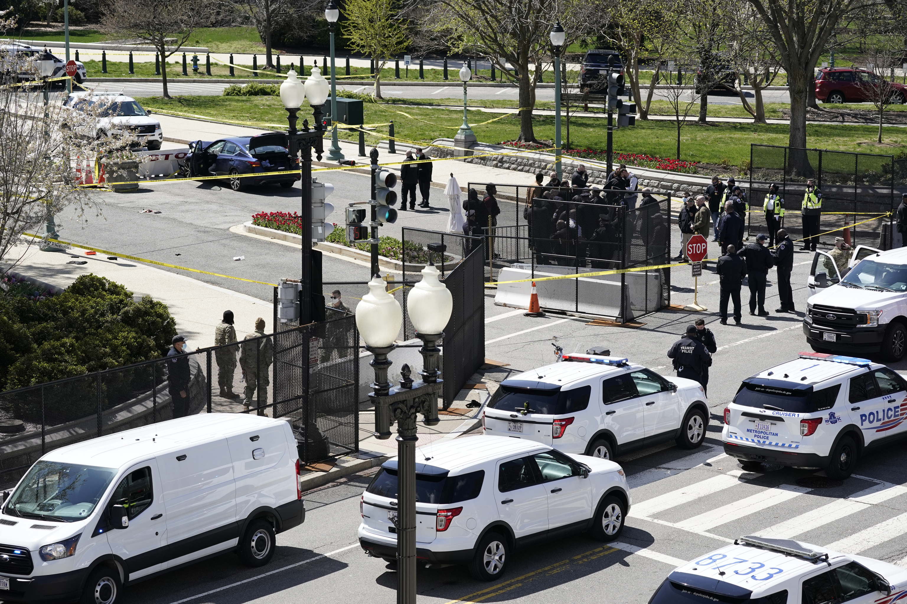 Police officers gather near a car that crashed into a barrier on Capitol Hill in Washington