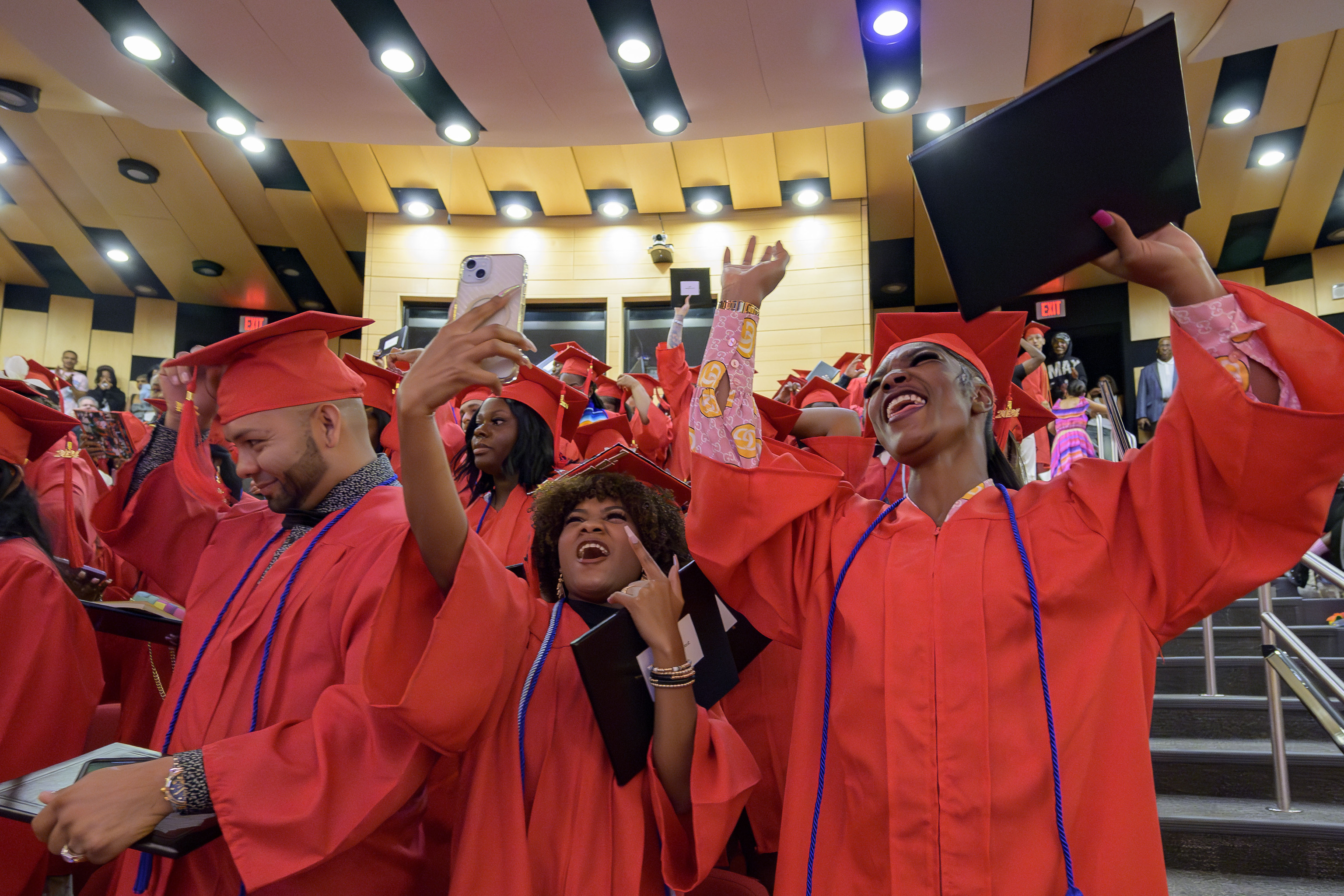 Keywanda Ashley, right, and Naomy Seiry Arzu Cruz, and Darwin Argueta, left, celebrate after receive their high school equivalency (HiSET) diplomas