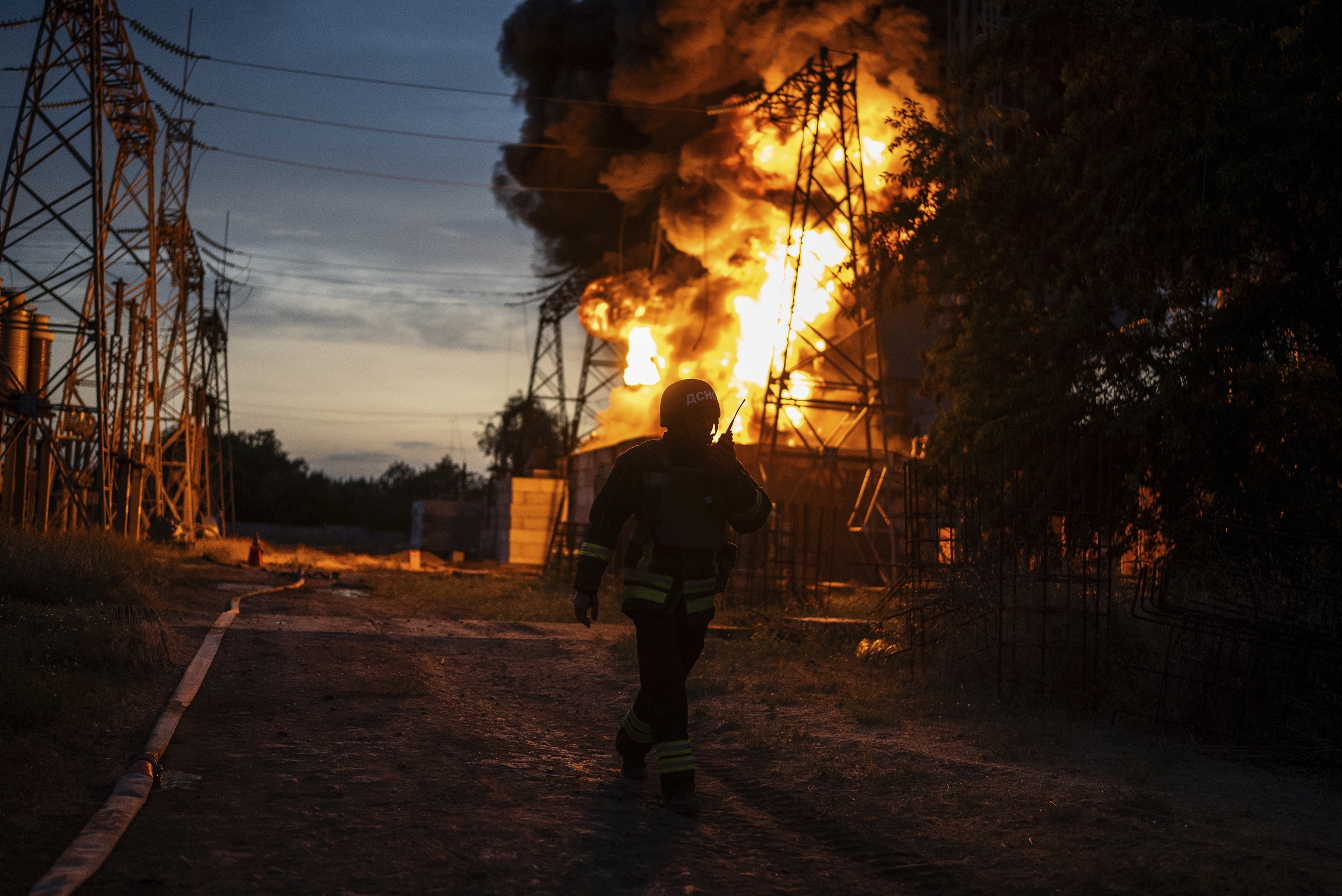 A Ukrainian firefighter talks on the radio while he works to extinguish the fire