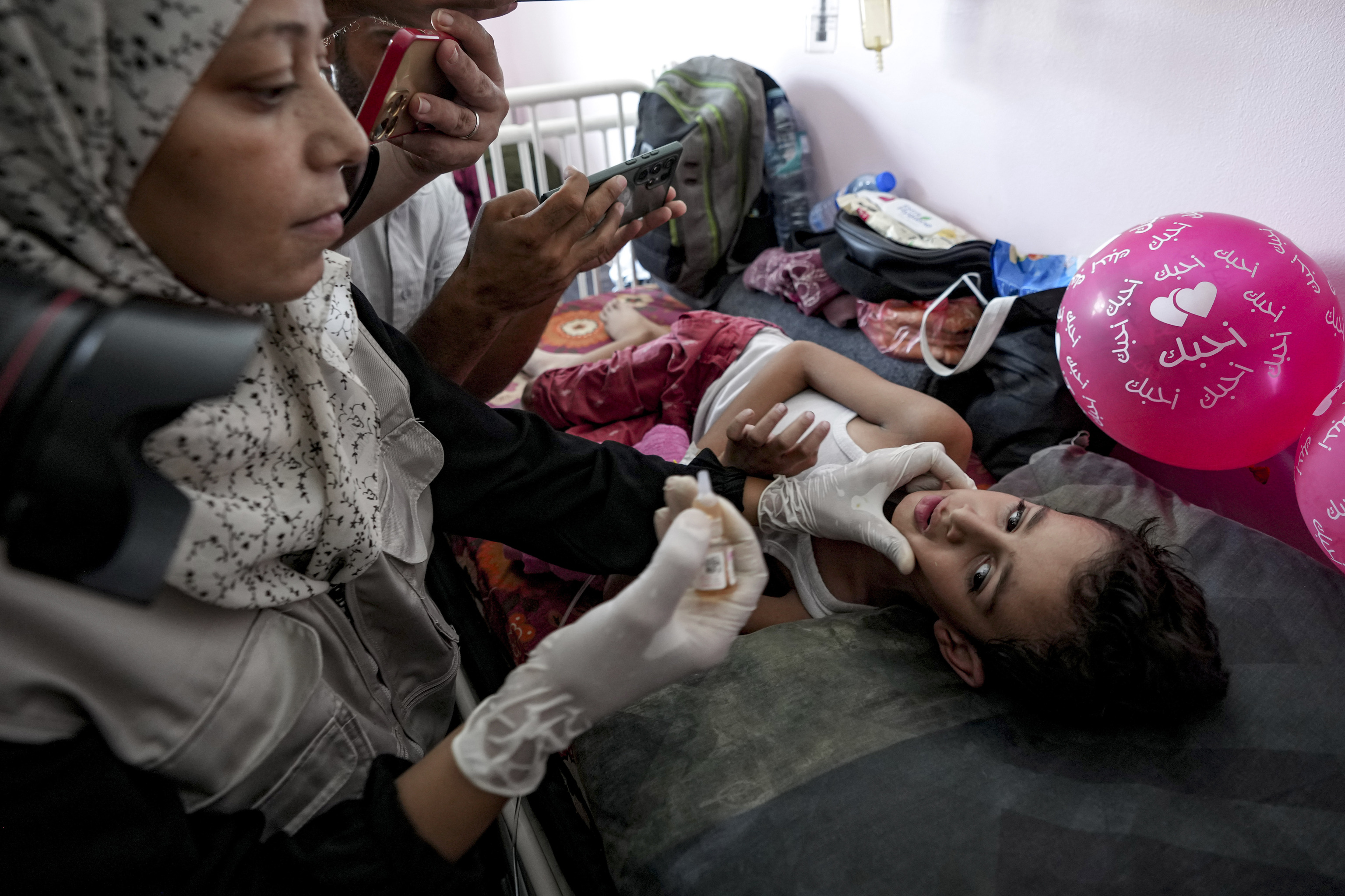 A health worker administers a polio vaccine to a child at a hospital in Deir al-Balah, central Gaza Strip