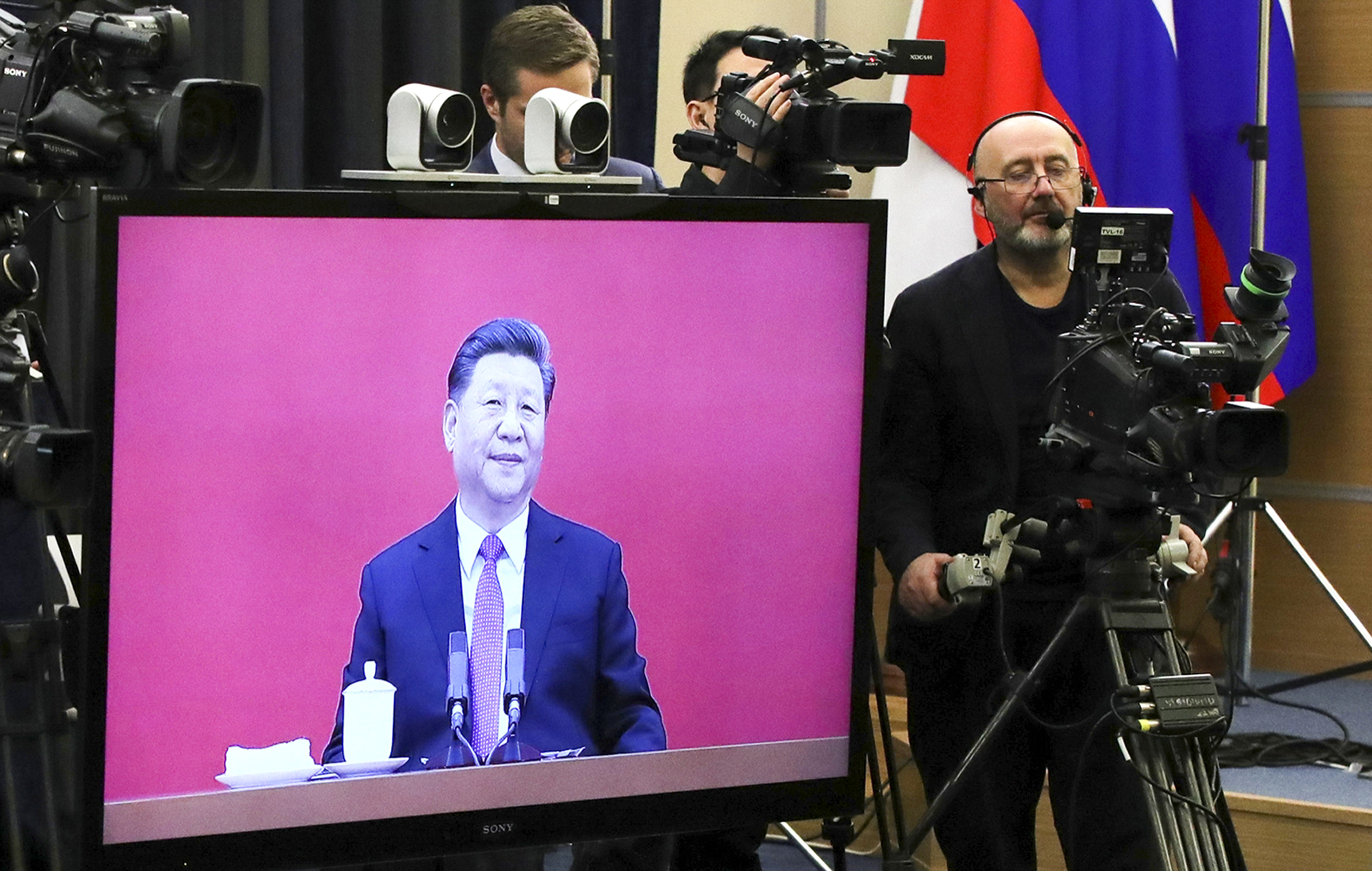 Chinese President Xi Jinping seen on a TV screen as he attends a joint video conference with Russian President Vladimir Putin