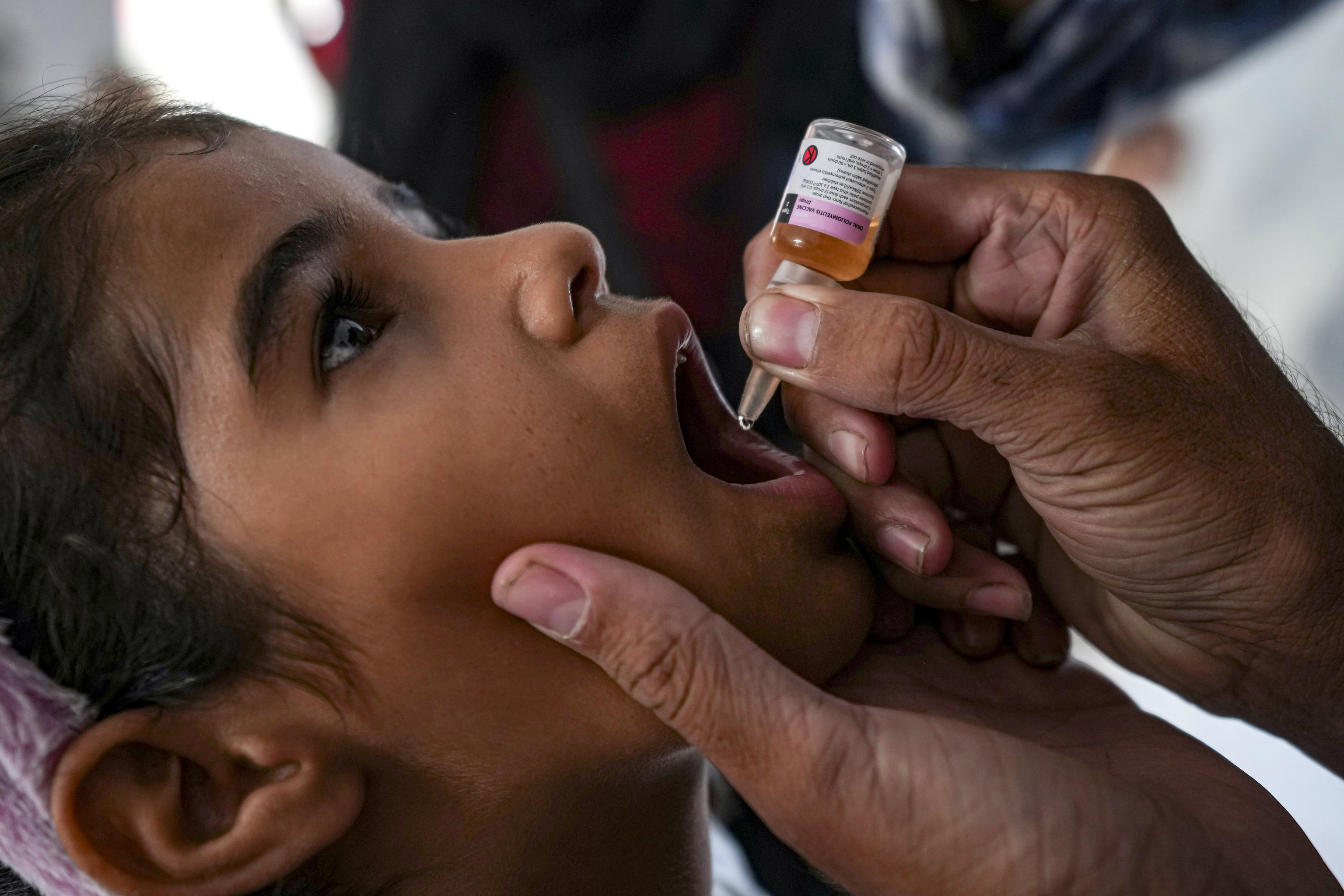 A health worker administers a polio vaccine to a girl at a hospital in Deir al-Balah, Gaza Strip.