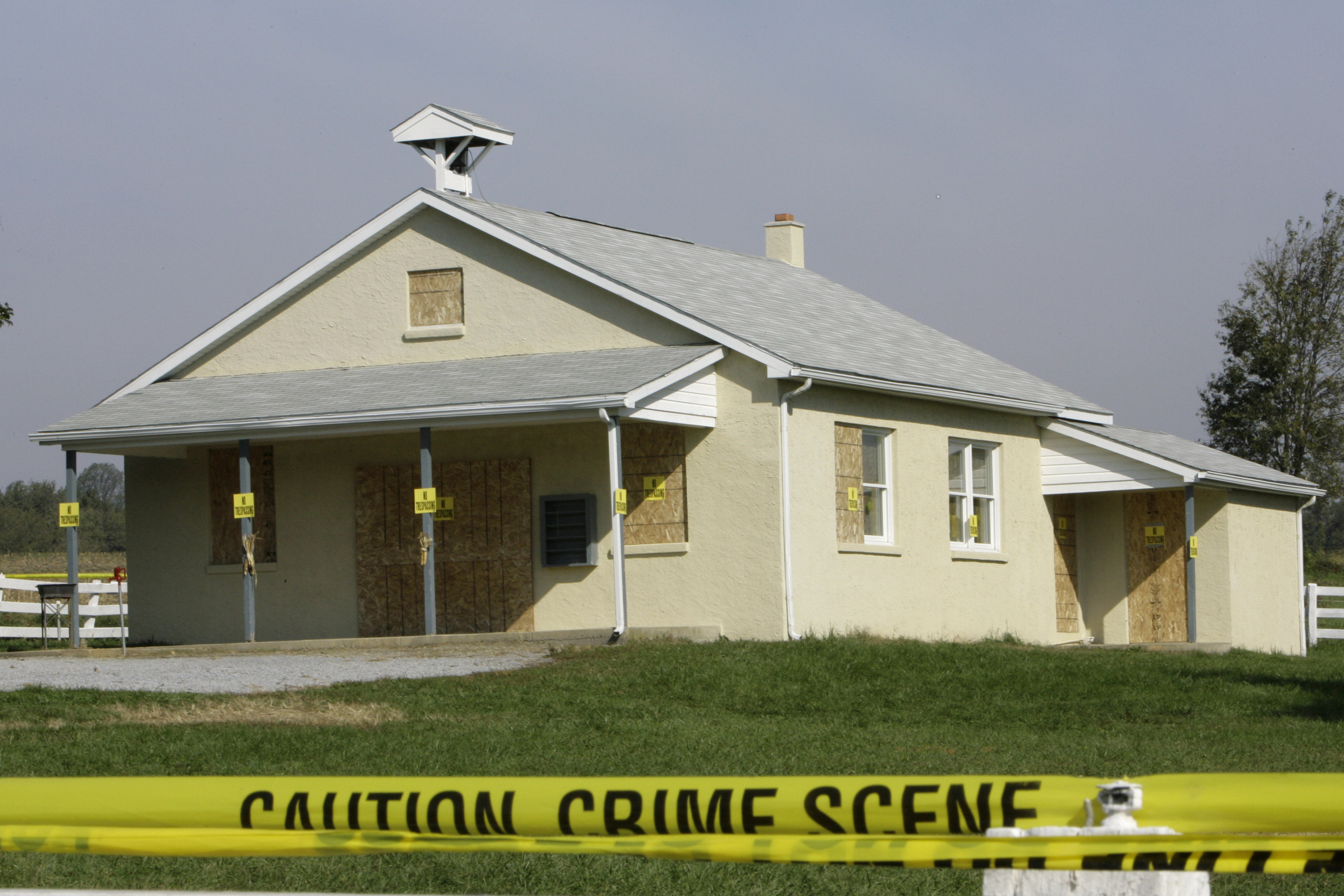 Crime scene tape is seen surrounding the boarded-up schoolhouse in Nickel Mines