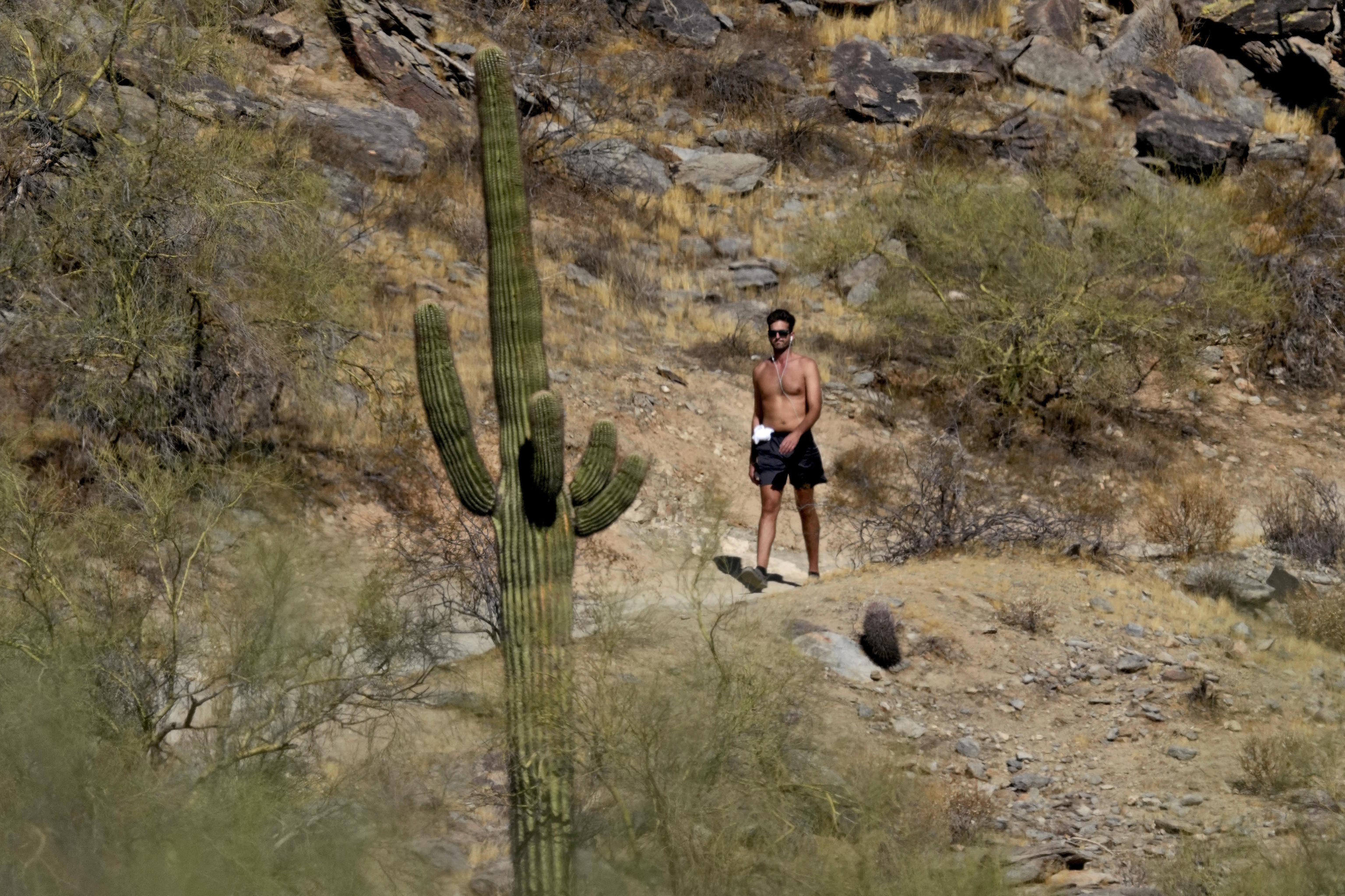 A hiker takes advantage of lower morning temperatures as unseasonably high temperatures are expected this week across the western U.S and Phoenix.