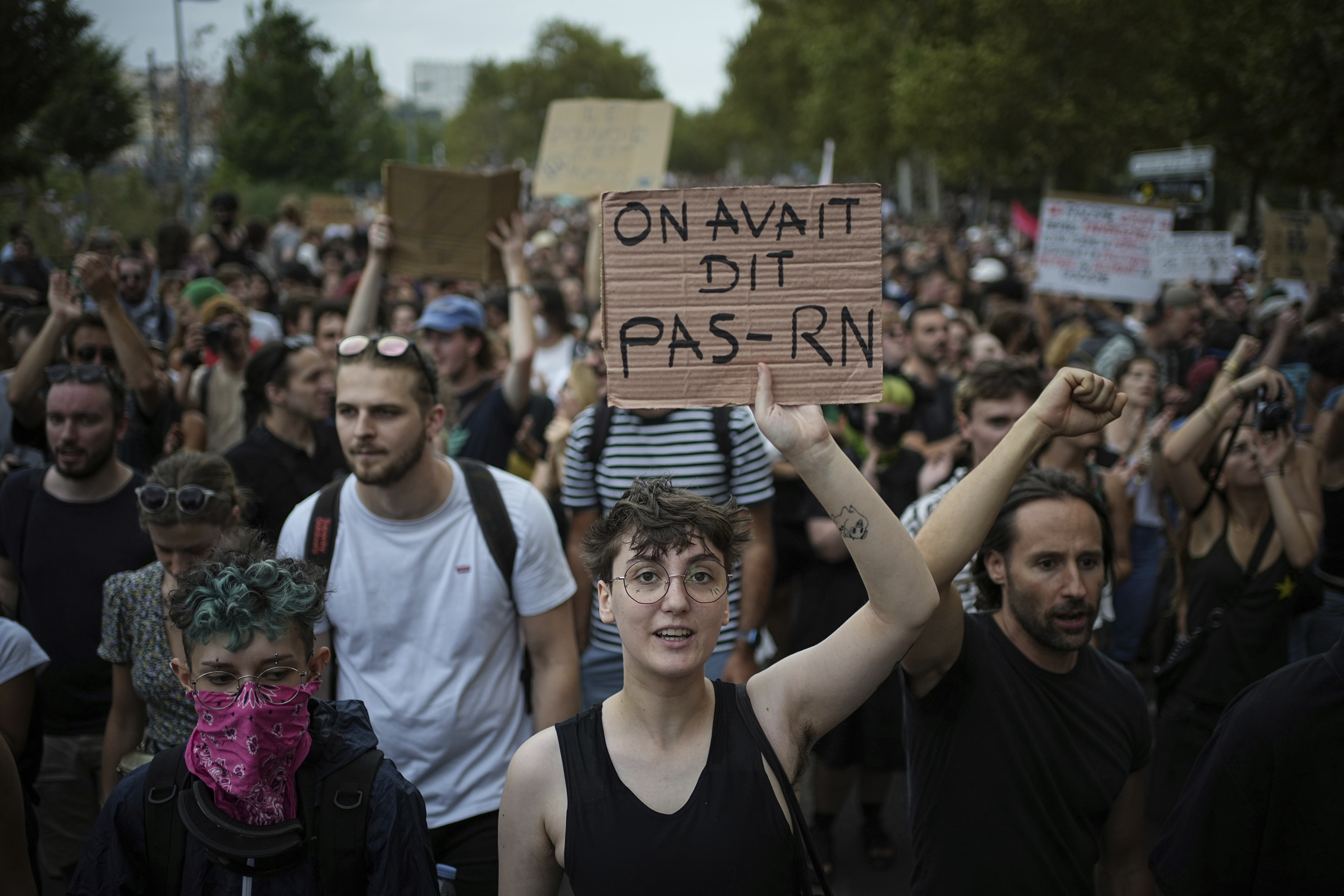 A woman holds a banner saying 'We said no Rassemblement National' as demonstrators participate in a protest.