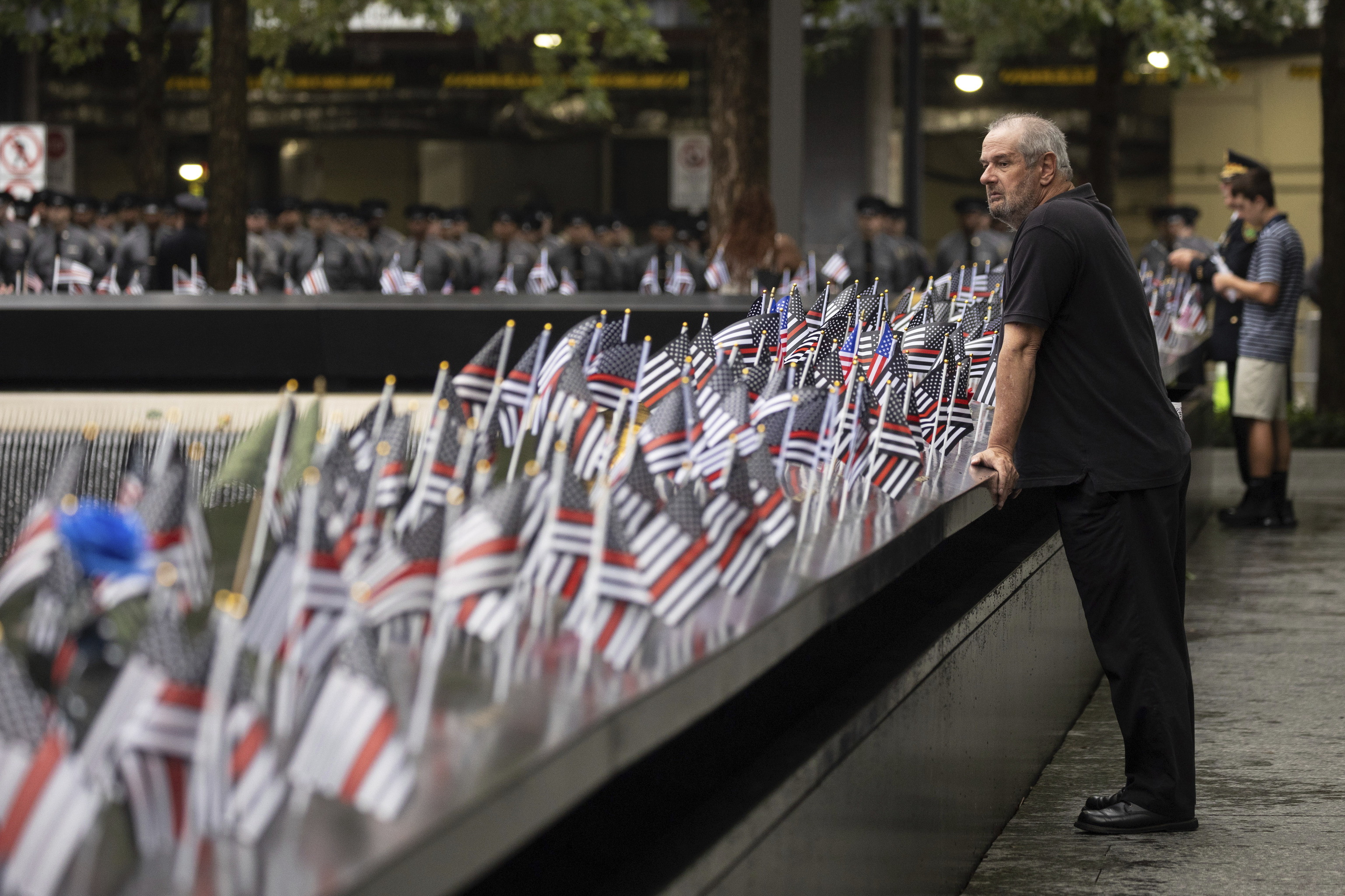 A person looks at flags before the commemoration ceremony of the Sept. 11, 2001, terror attacks