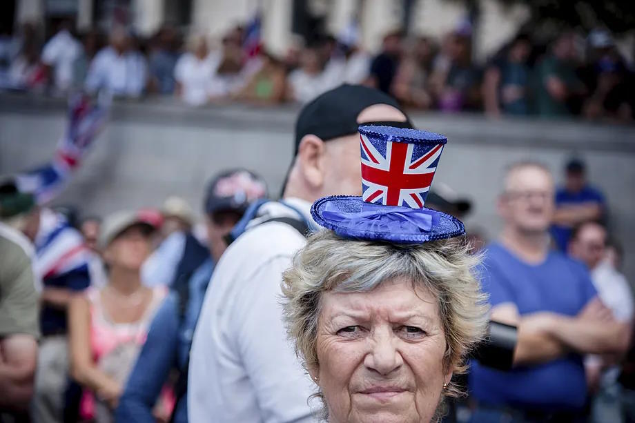 An activist poses with a hat featuring the flag of the UK in London.