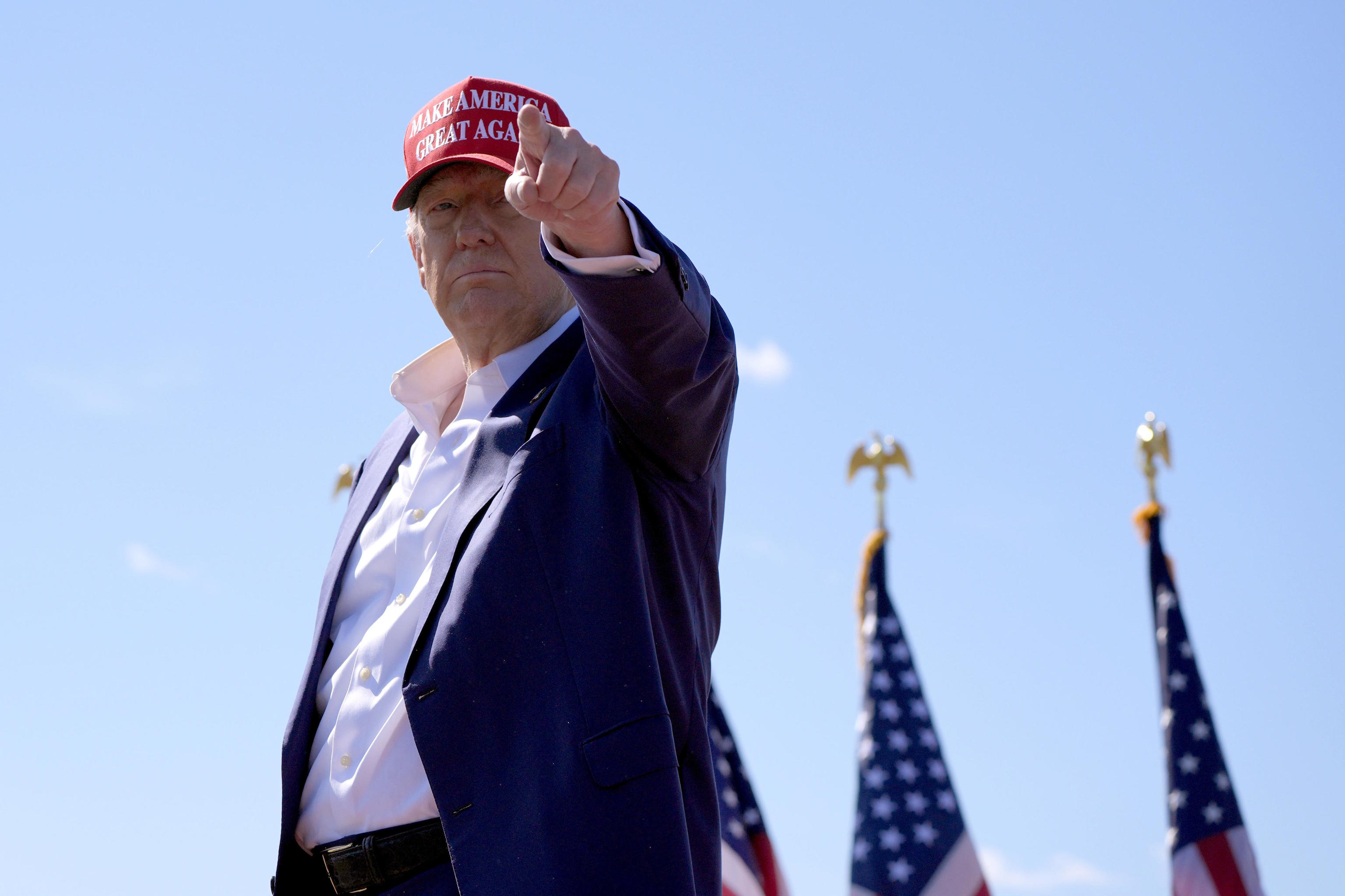 Trump gestures as he departs a campaign event at Central Wisconsin Airport.