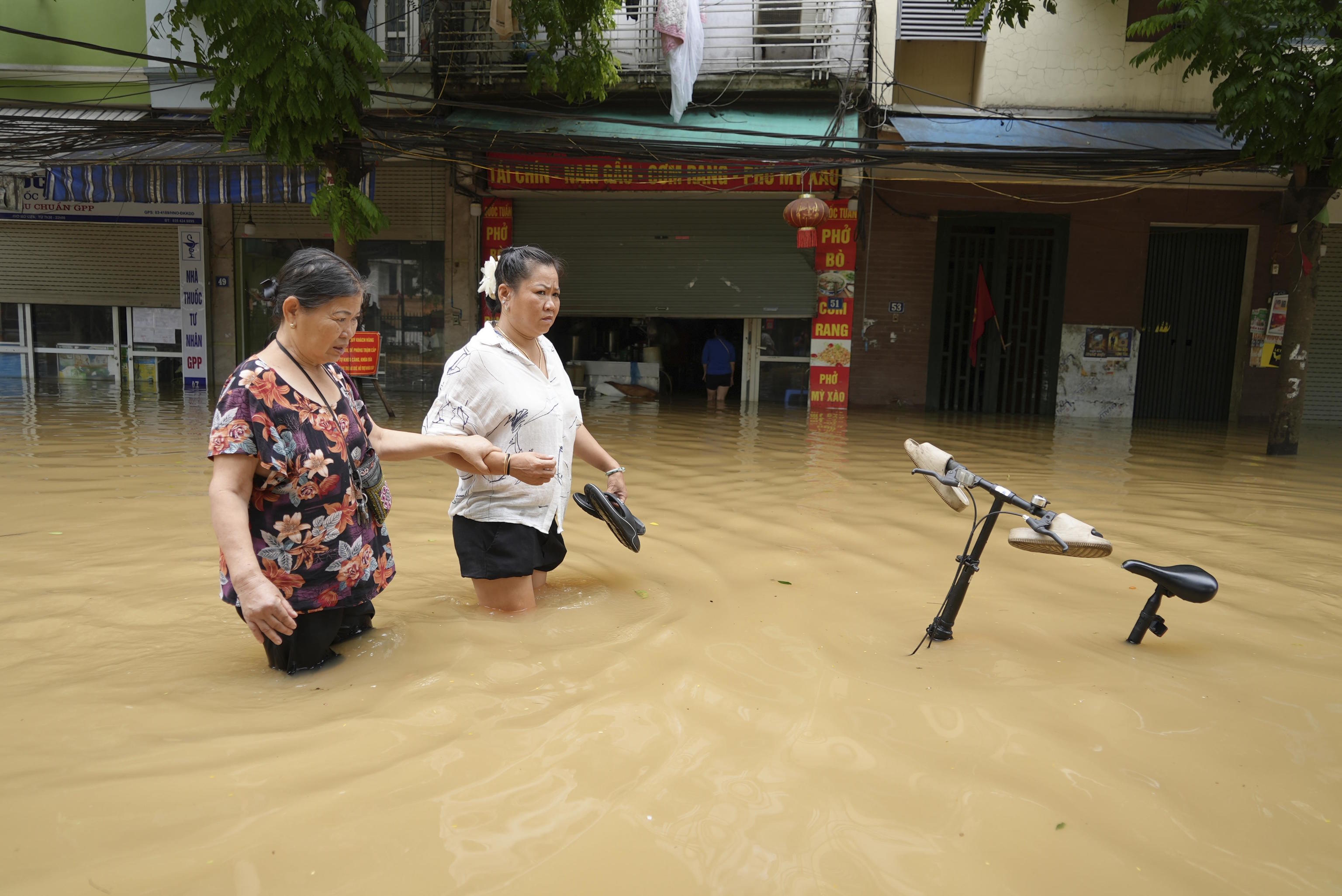 People wade in a flooded street in the aftermath of Typhoon Yagi, in Hanoi.