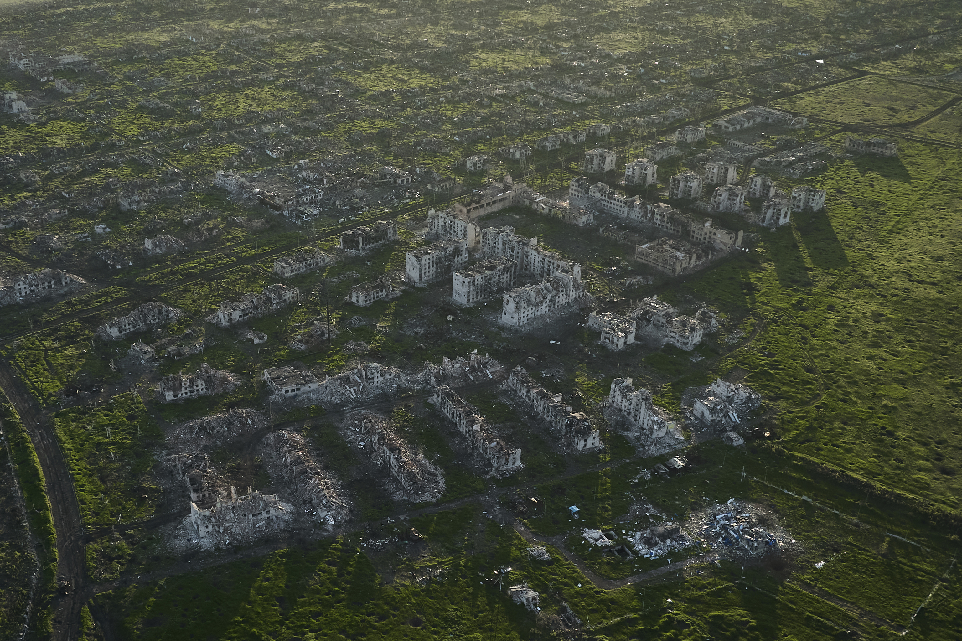 Residential buildings razed to the ground and shell craters are seen on an aerial view of Maryinka