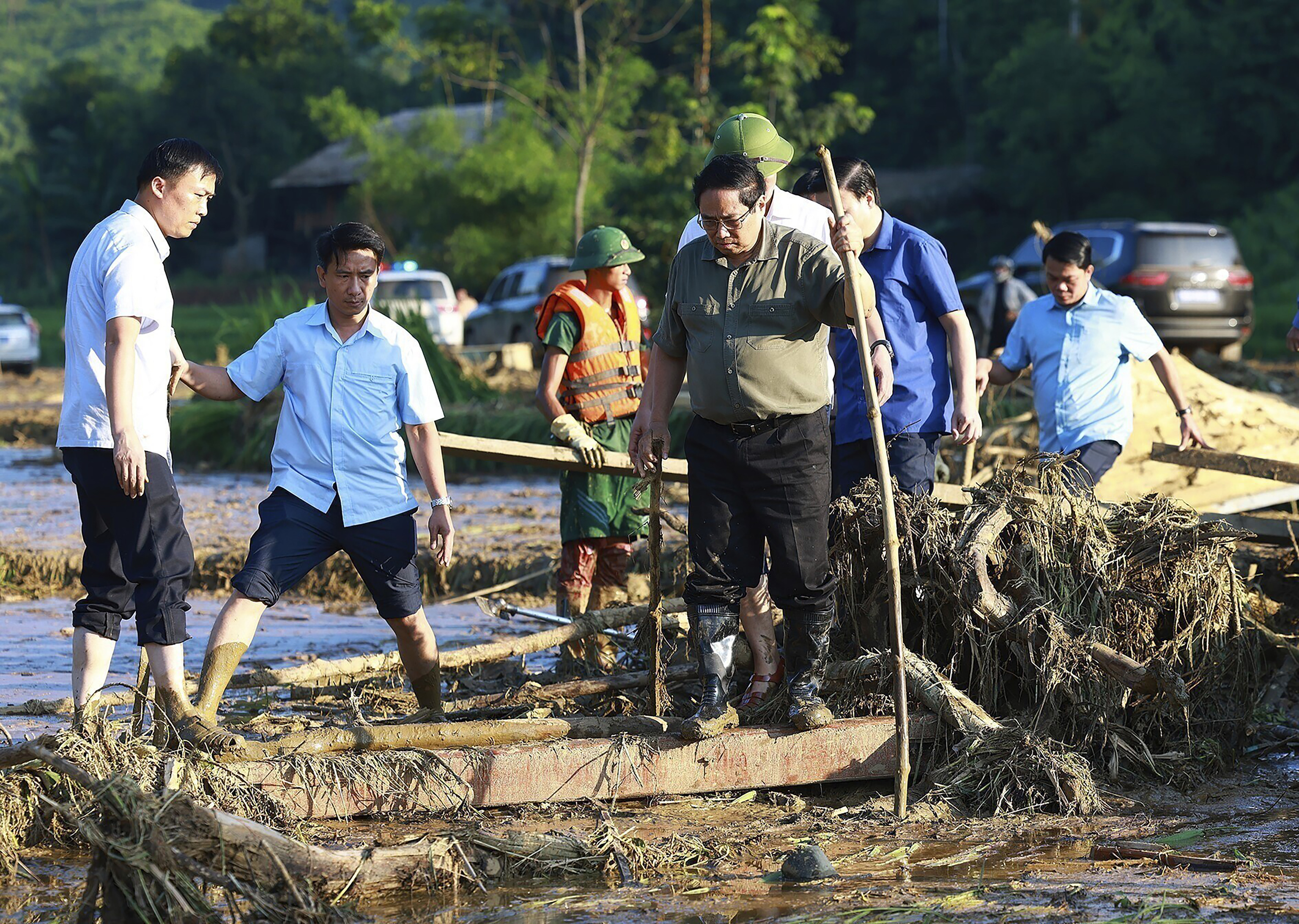 Vietnam's Prime Minister Pham Minh Chinh, foreground right, visits as rescue work