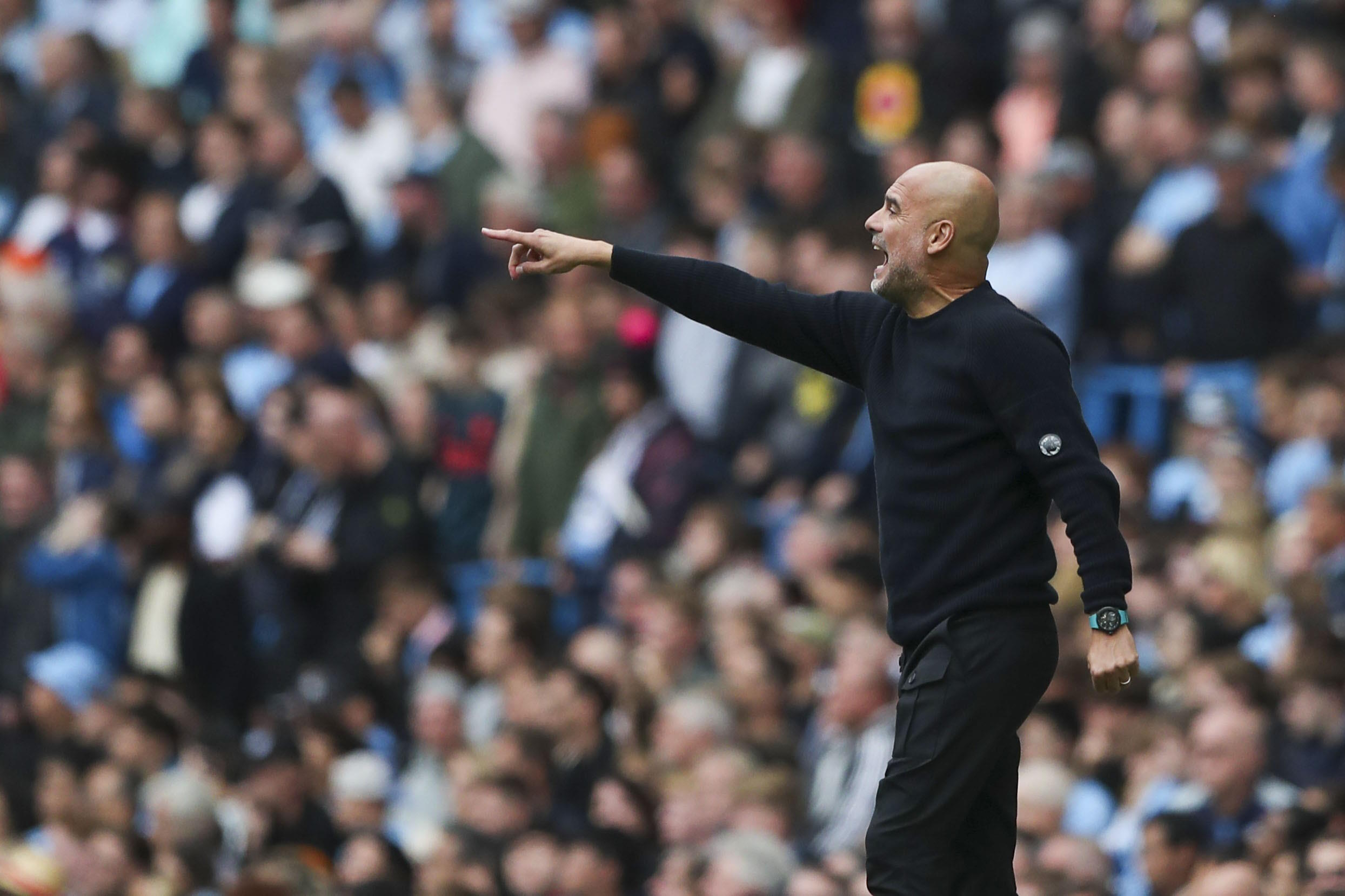 Manchester City's head coach Guardiola gives instructions to his players.