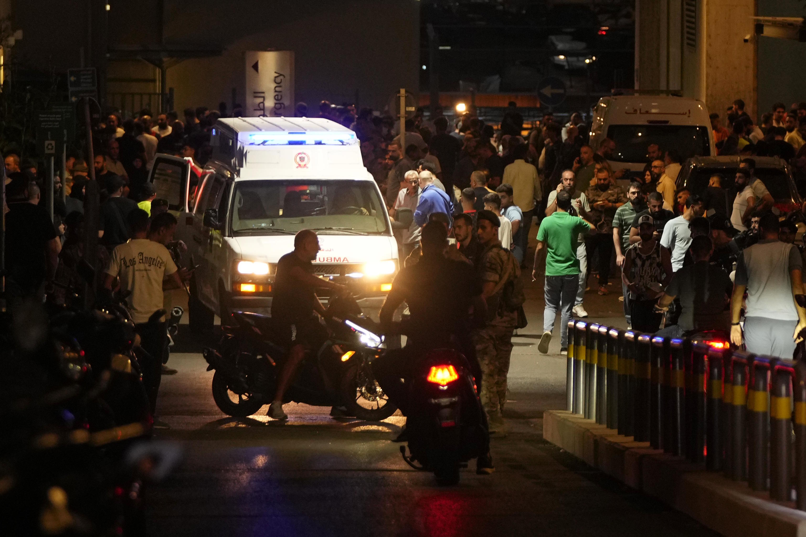 People gather around an ambulance carrying wounded people.