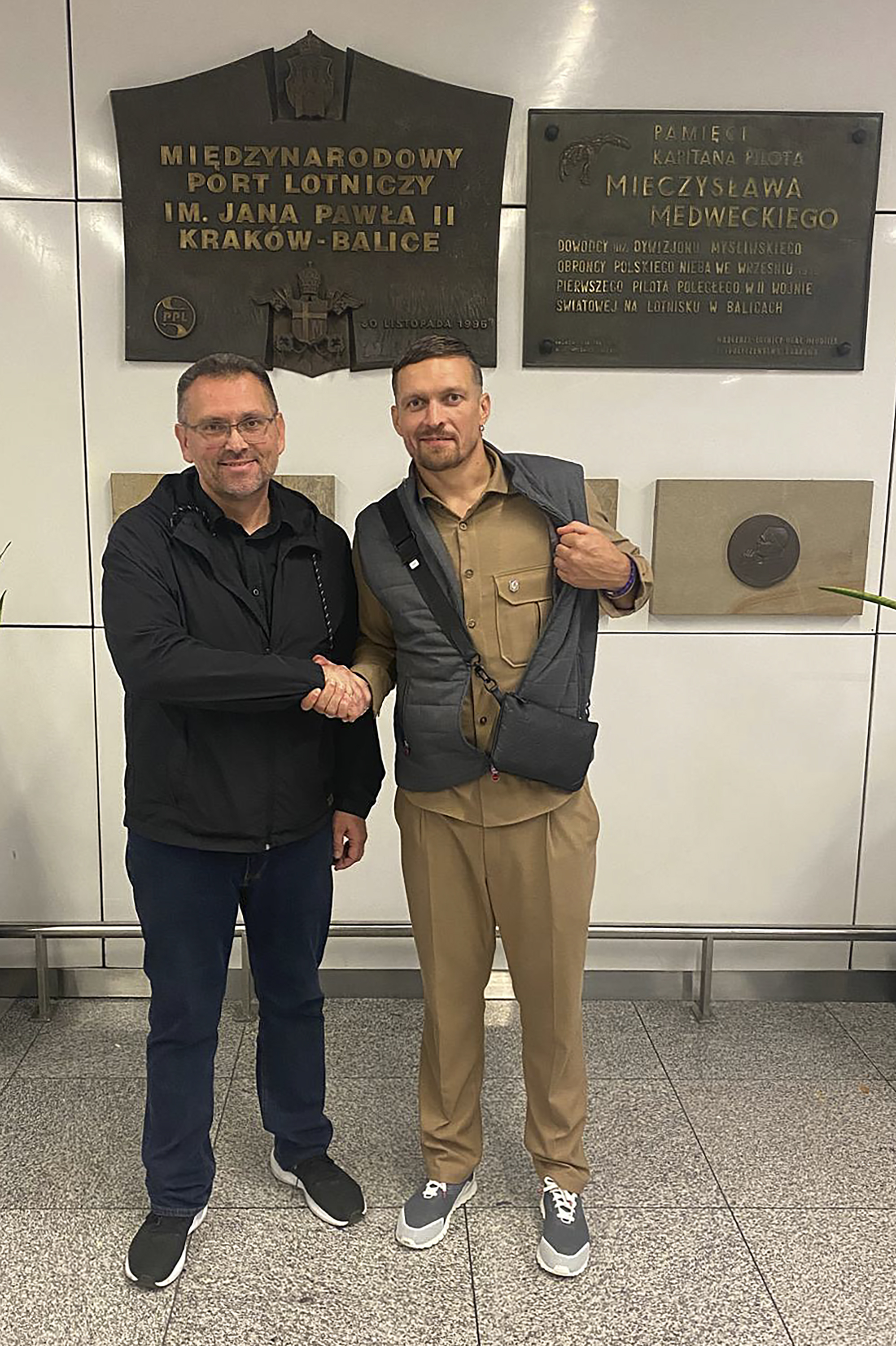 Heavyweight boxing champion Oleksandr Usyk, right, shakes hands with Ukrainian Consul General in Krakow