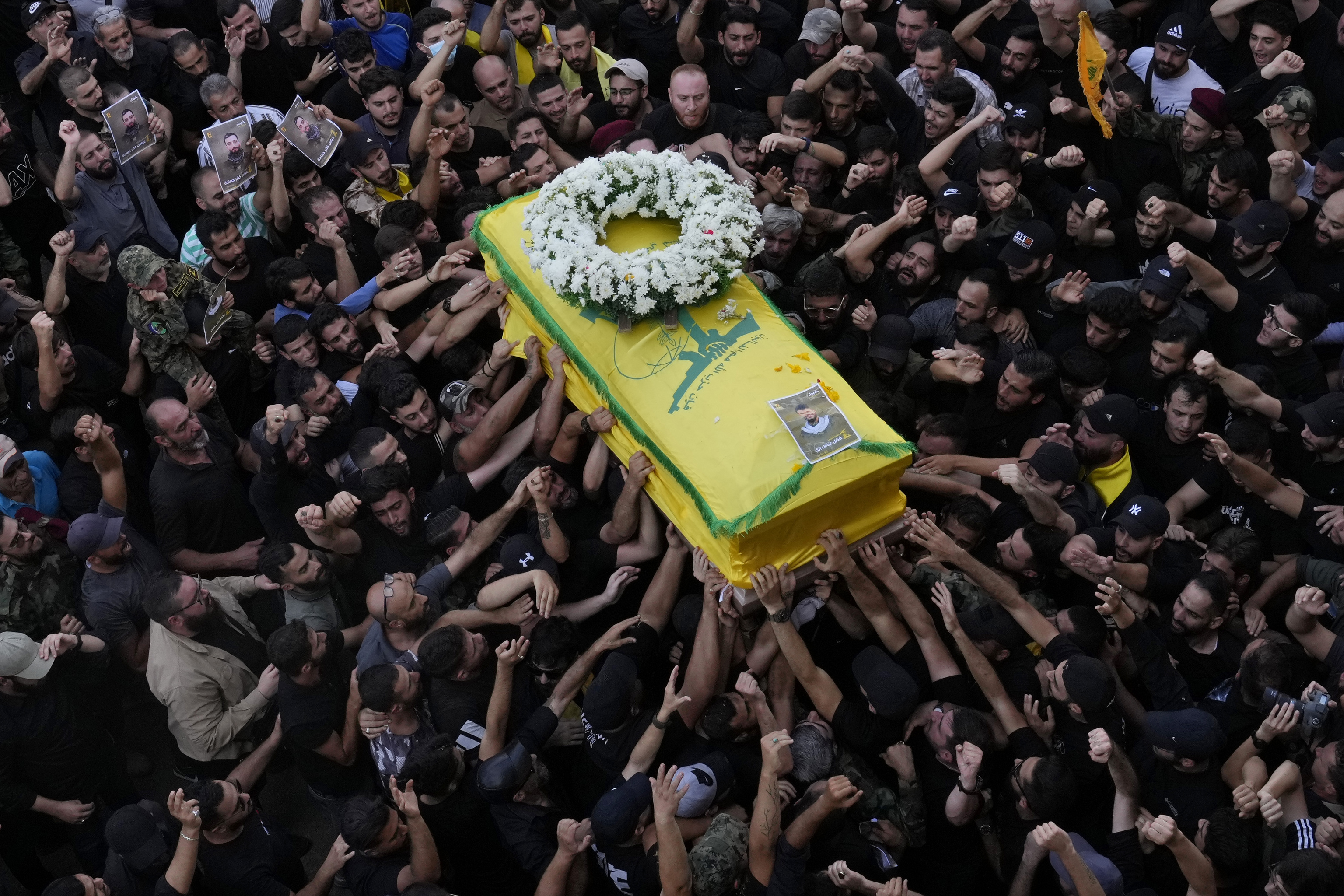 Hezbollah members carry the coffin of their comrade who was killed when a handheld device exploded