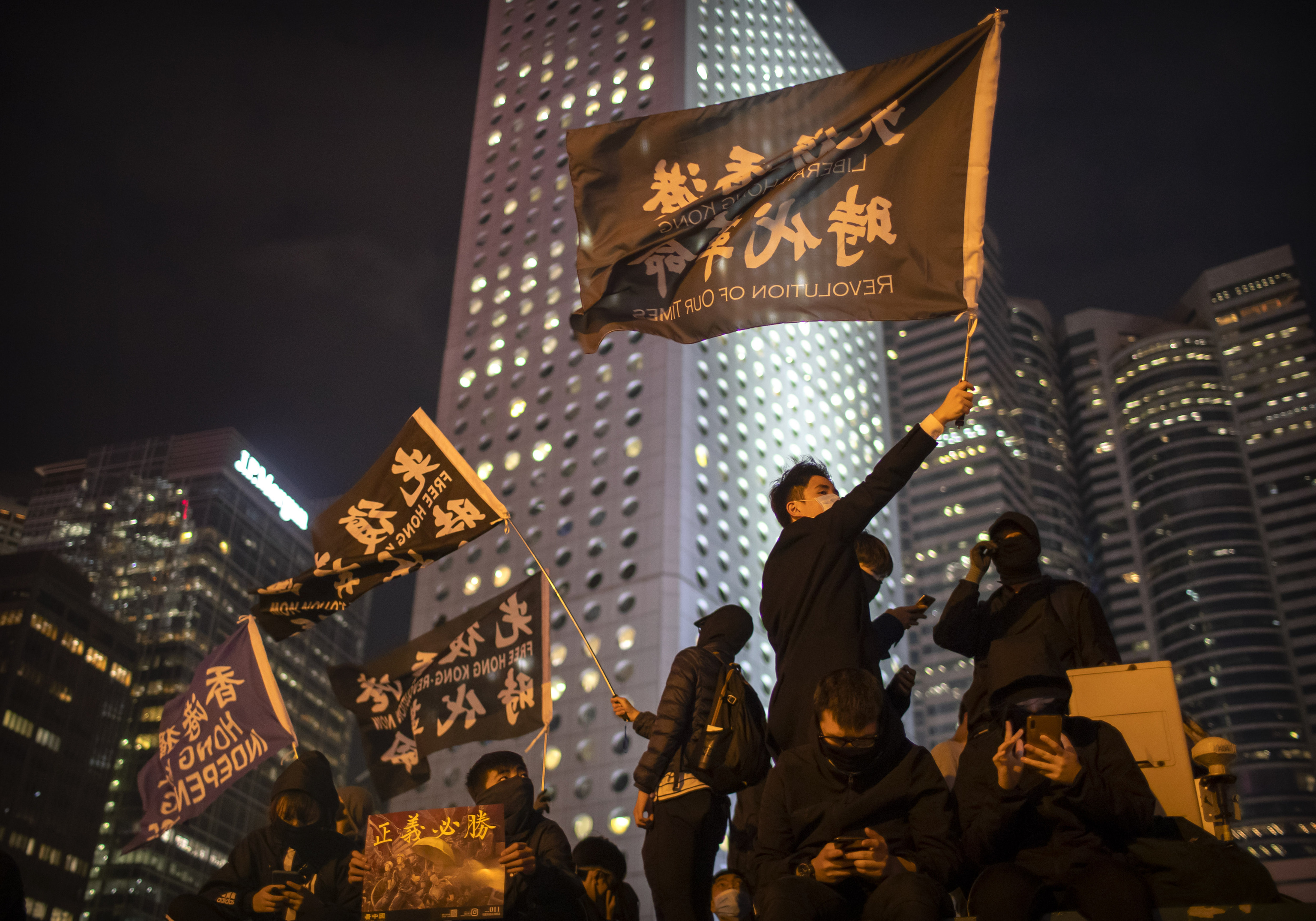 A protestor holds a flag that reads: "Liberate Hong Kong, Revolution of Our Times"