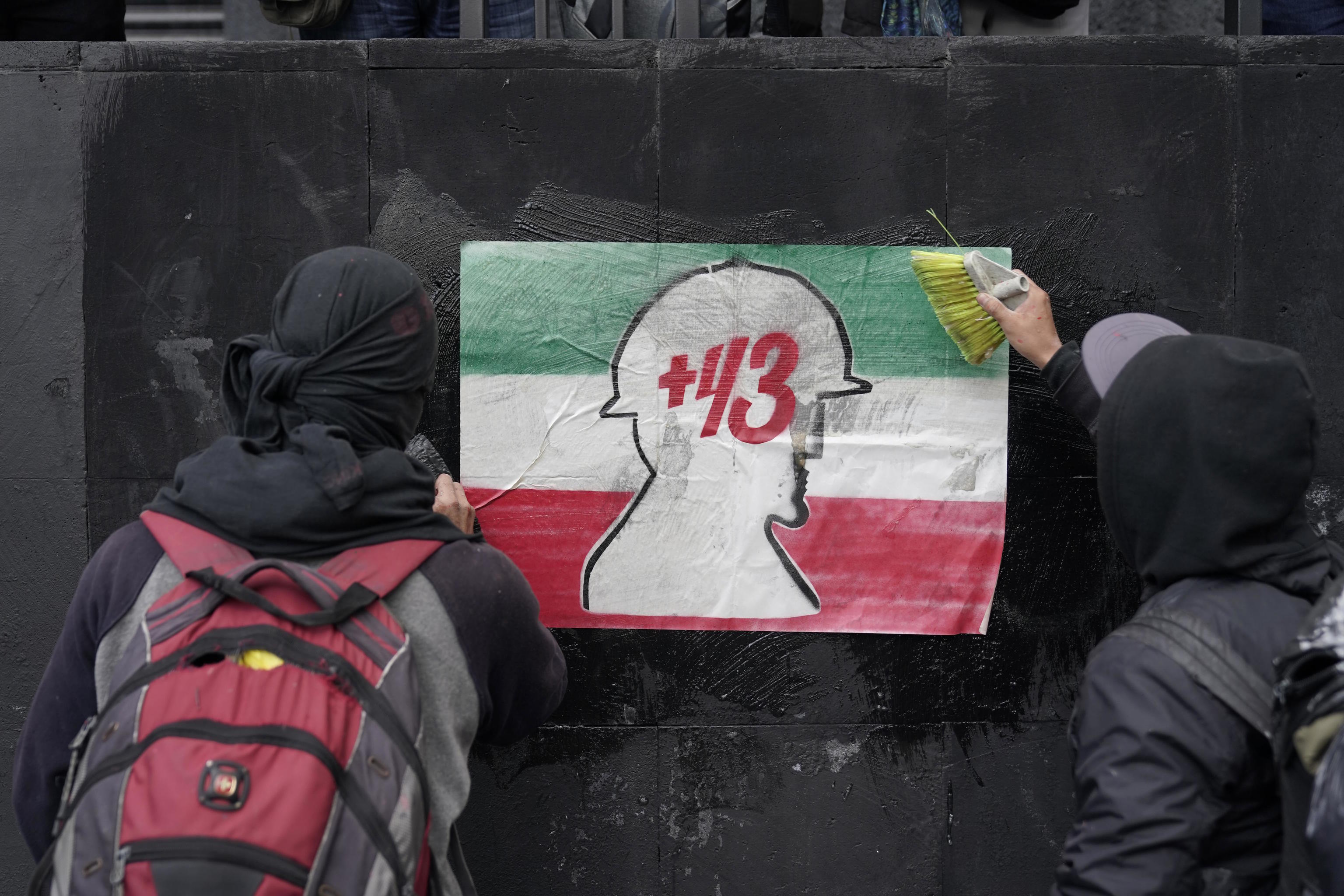 Demonstrators post a sign of the missing 43 Ayotzinapa college students.