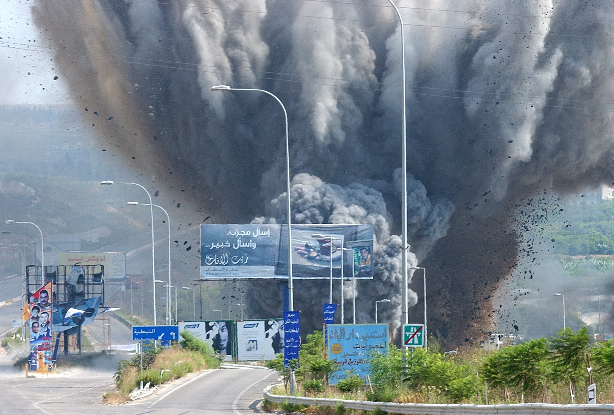 Smoke rises and debris flies from a bridge as it is targeted by an Israeli air raid.