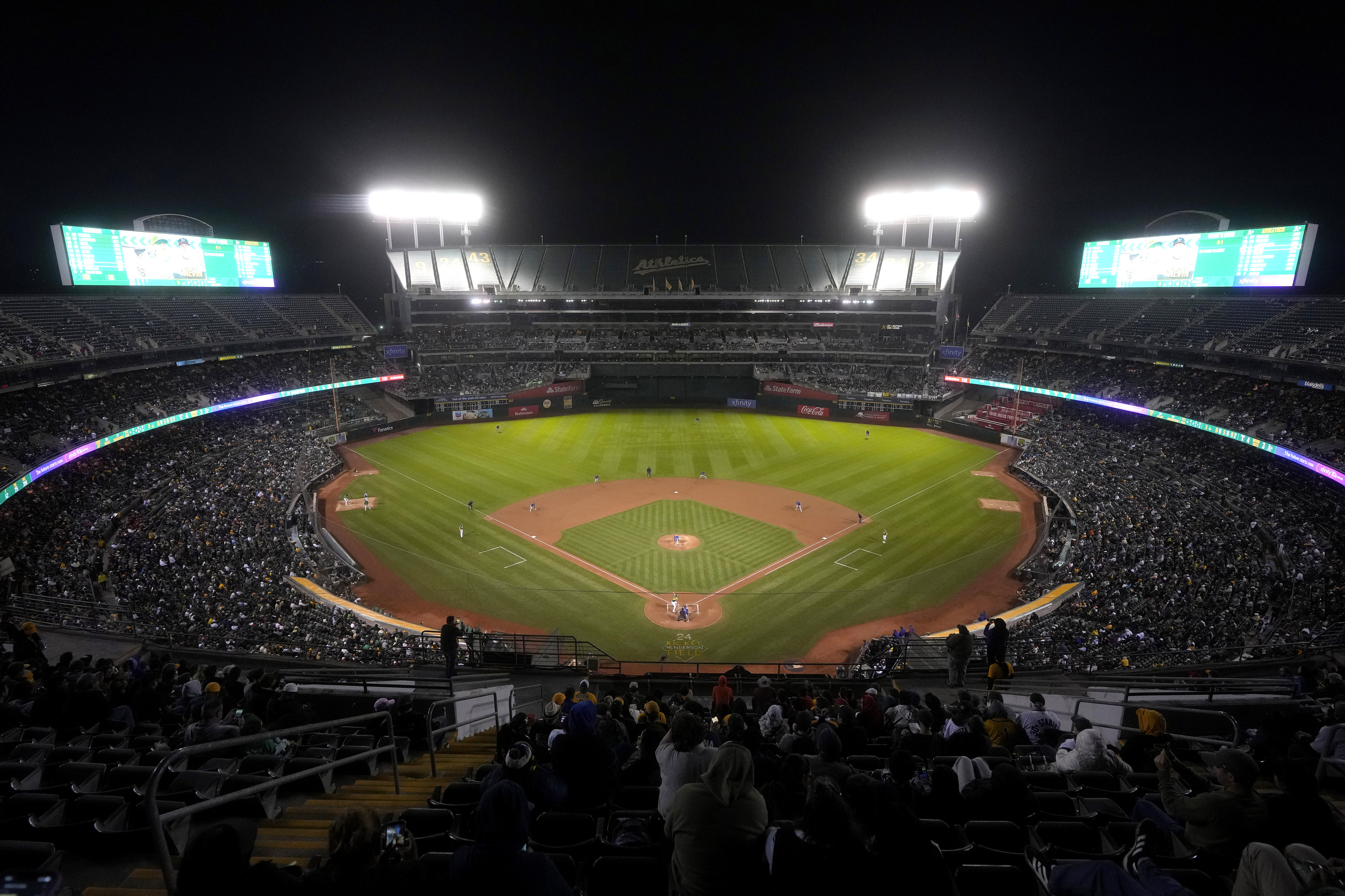 Fans at the Oakland Coliseum watch during the third inning of a baseball game between the Oakland Athletics and the Texas Rangers in Oakland