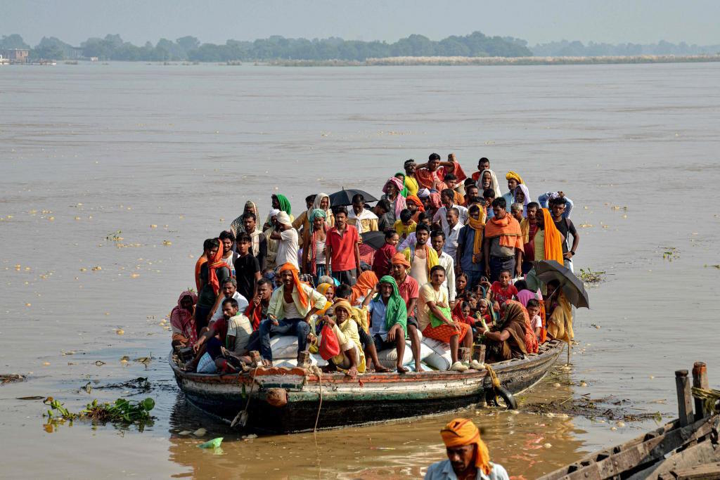 Flood-affected people along move after rise in the water level of Ganges.