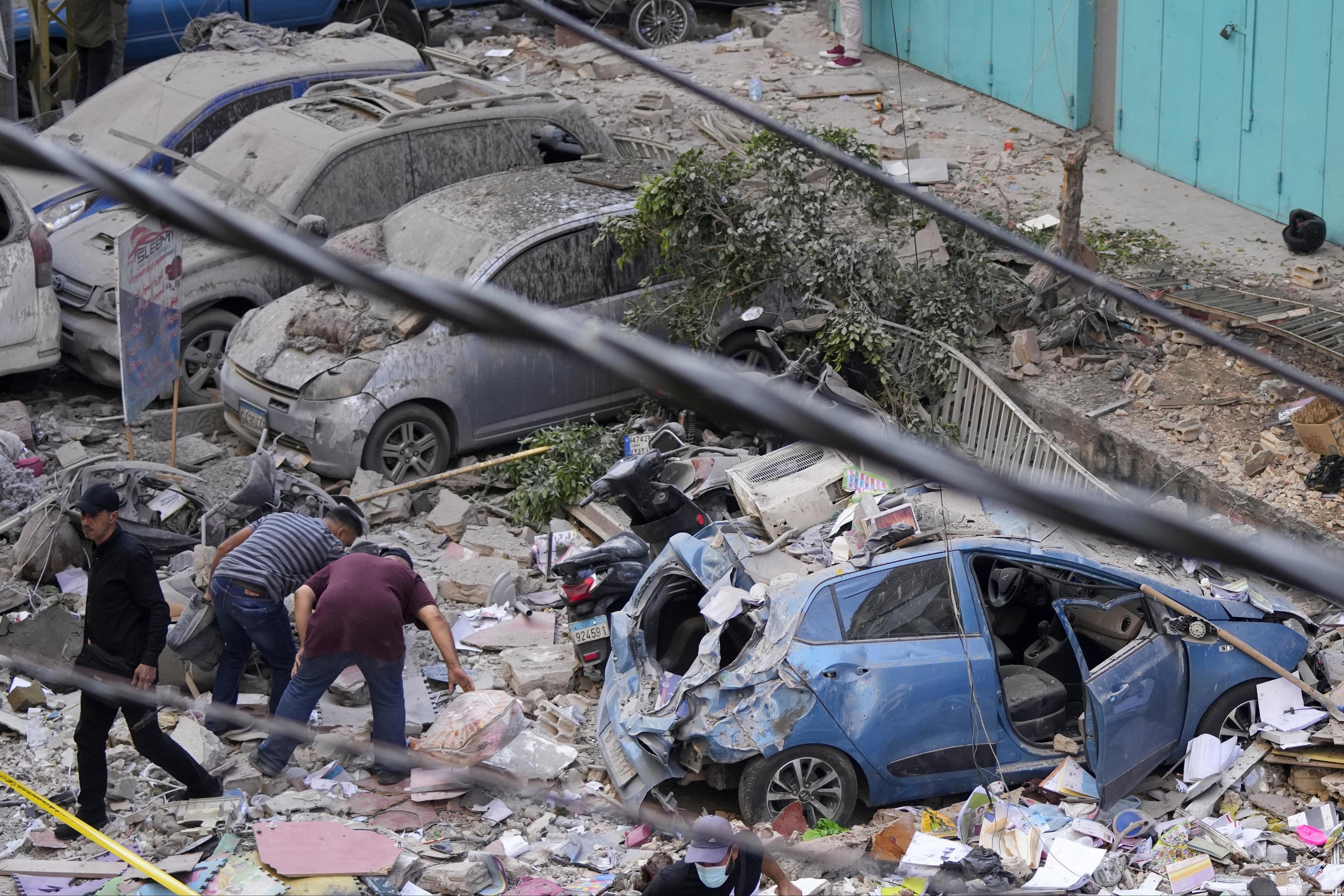 Residents check the site of an Israeli airstrike in Beirut's southern suburbs.