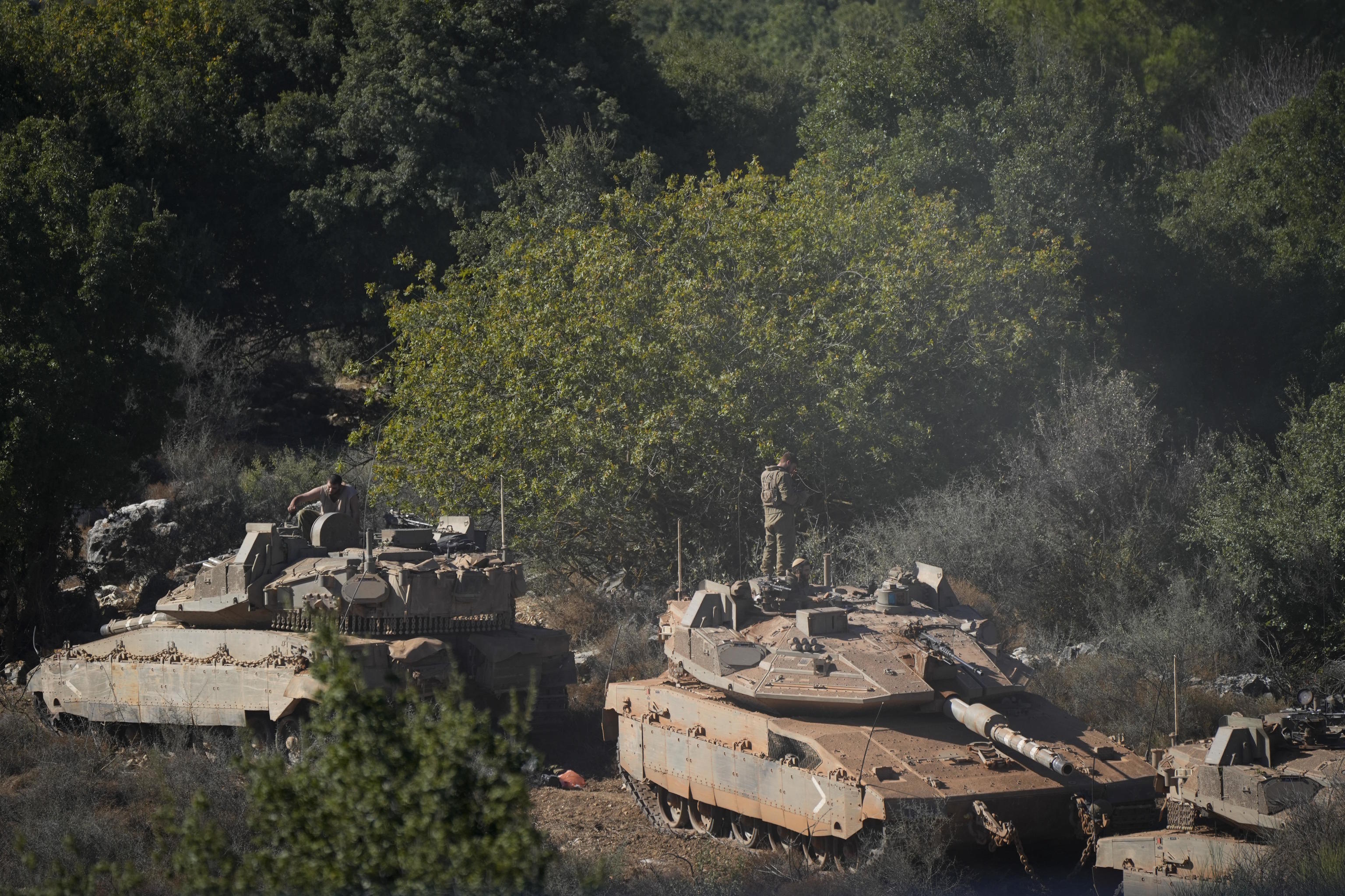 Israeli soldiers work on tanks in northern Israel.