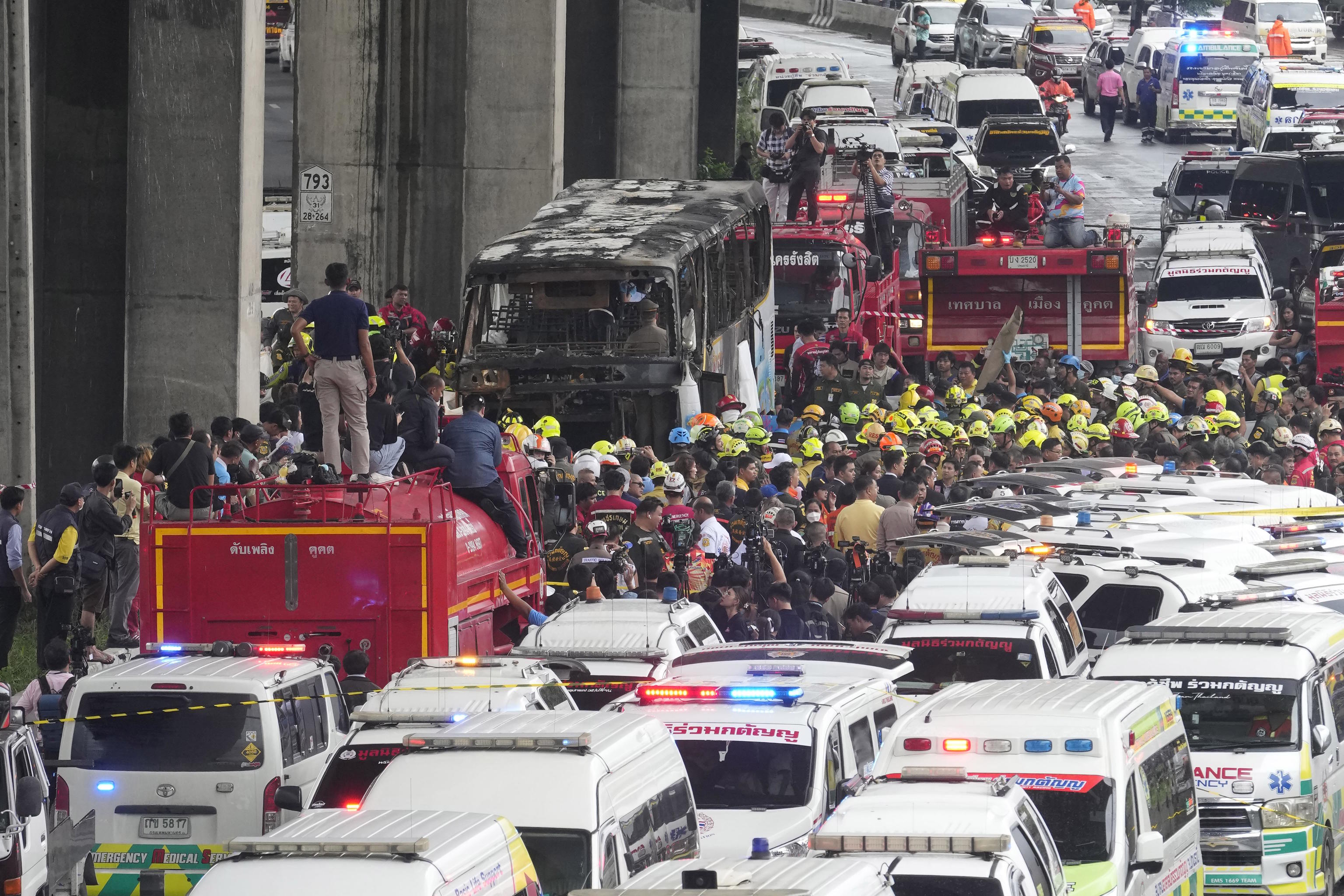 Rescuers gather at the site of a bus that caught fire.