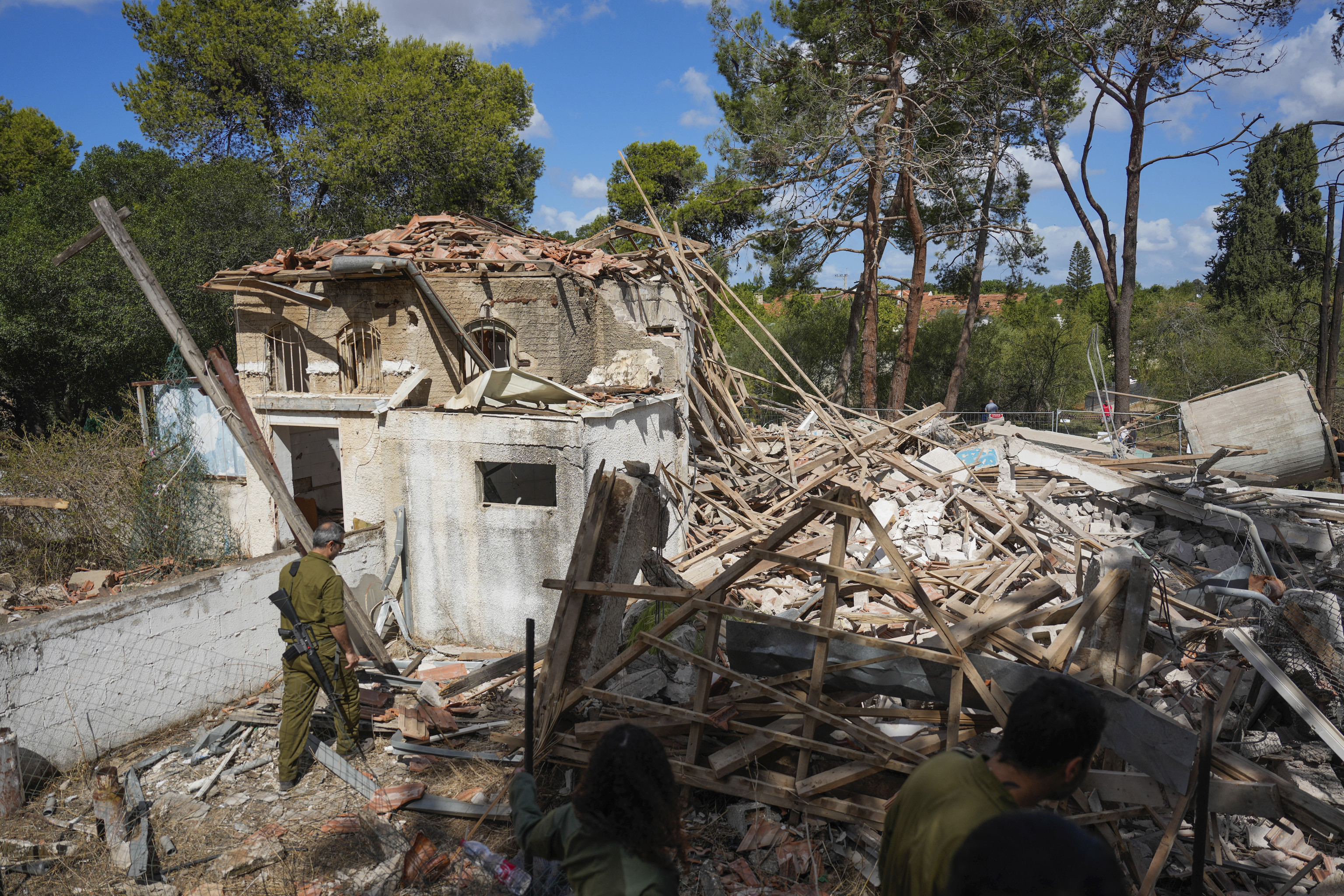 Israeli soldiers look at a destroyed building that was hit in Iran's missile attack in Hod Hasharon, Israel.