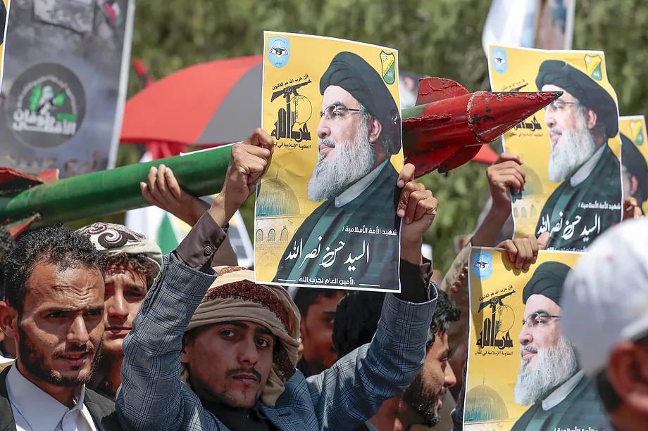 Followers of the Houthis carry Nasrallah's portrait.